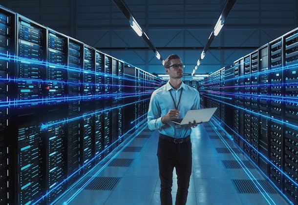 A man standing in a dedicated room full of IT servers