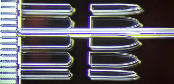 Passive fiber alignment and coupling onto silicon nitride photonic integrated circuits, realized by wafer-scale imprint of microstructures.