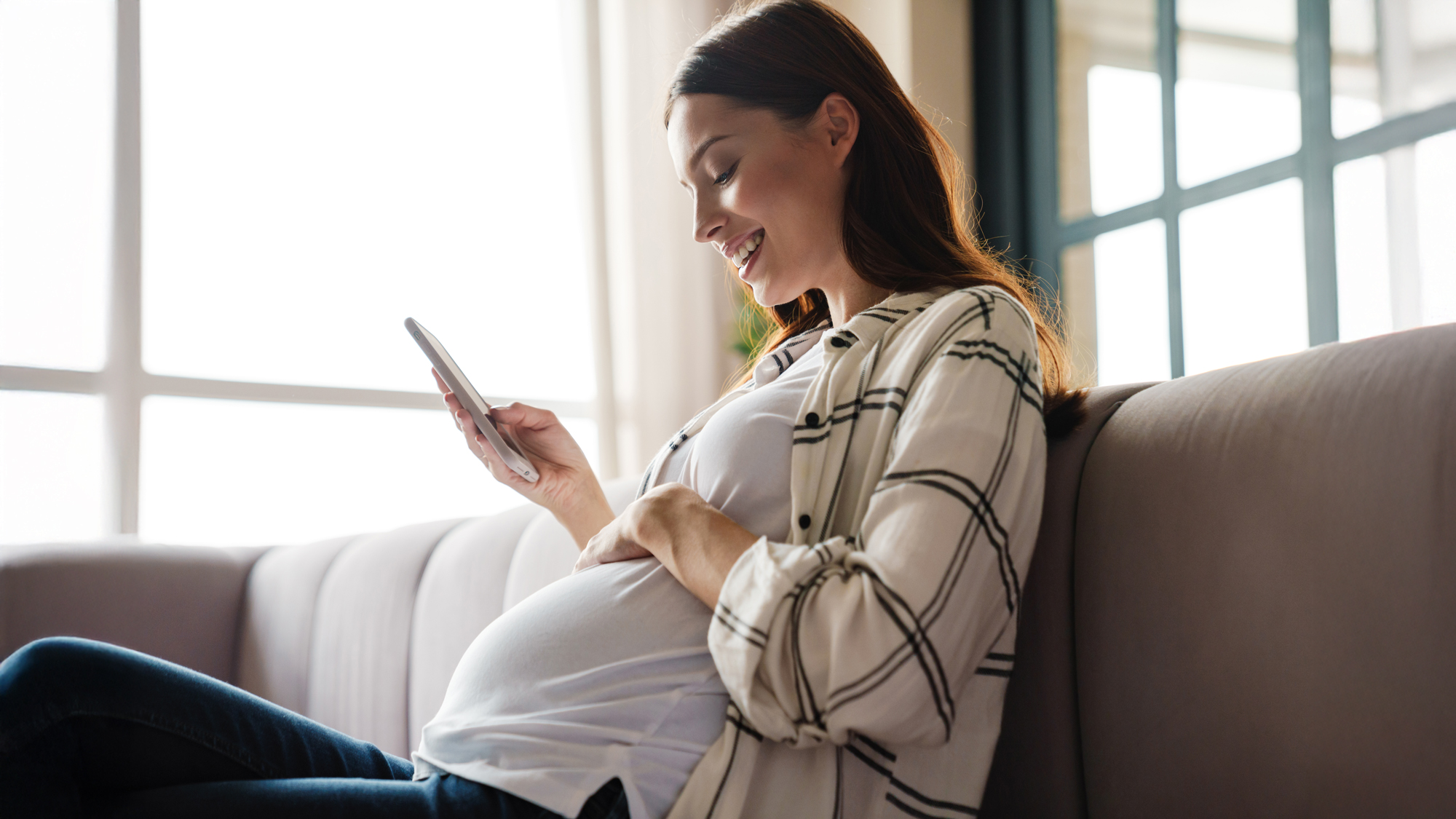 a pregnant woman sitting on a sofa