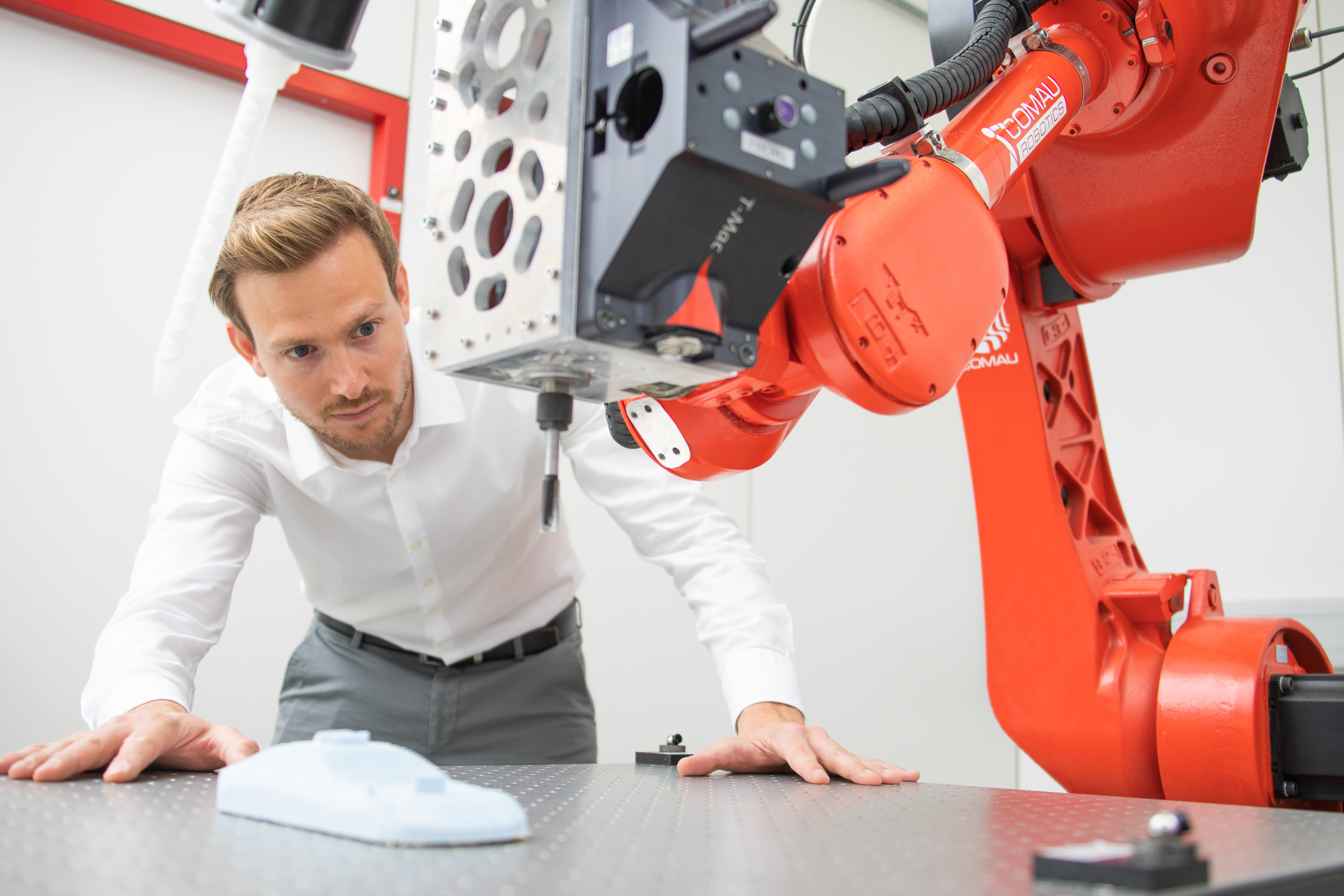 Man looking at Roboter arm 