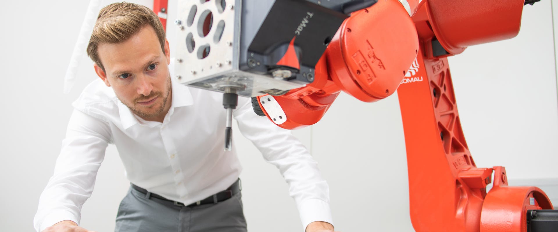 Man looking at Roboter arm