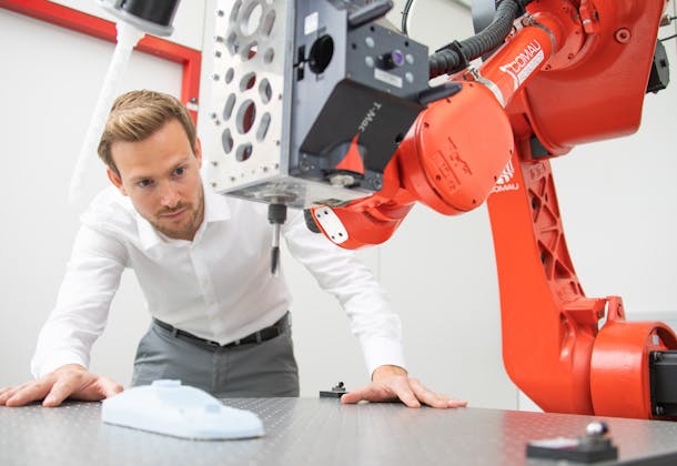 Man looking at Roboter arm