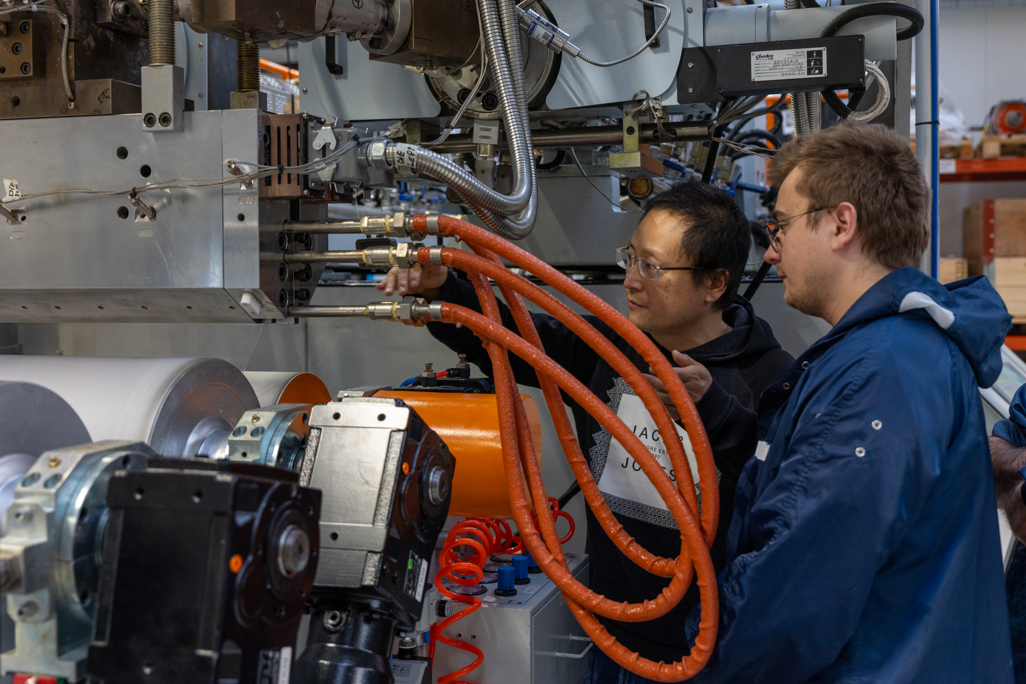 Two operators configuring a twin-screw extrusion machine