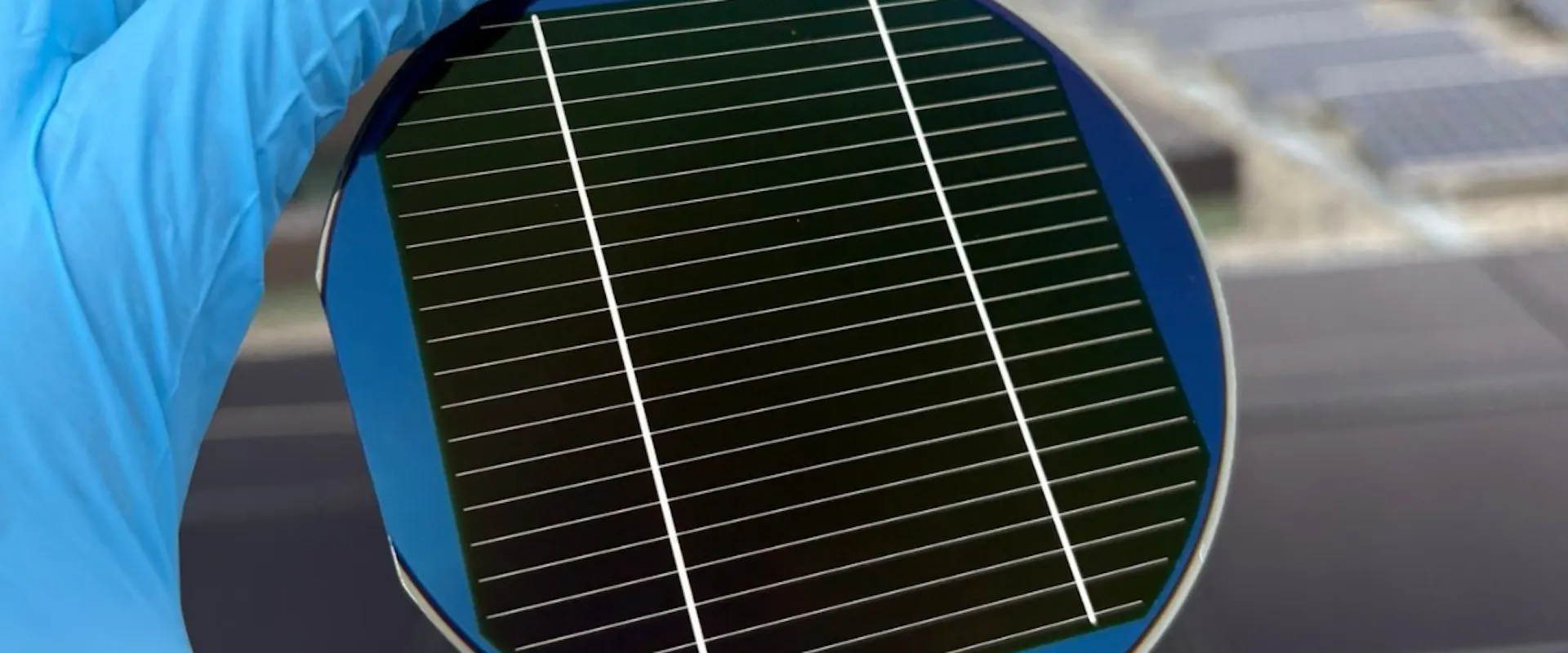 Person holding a triple-junction solar cell