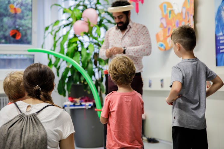 A balloon artist makes balloon animals for children.