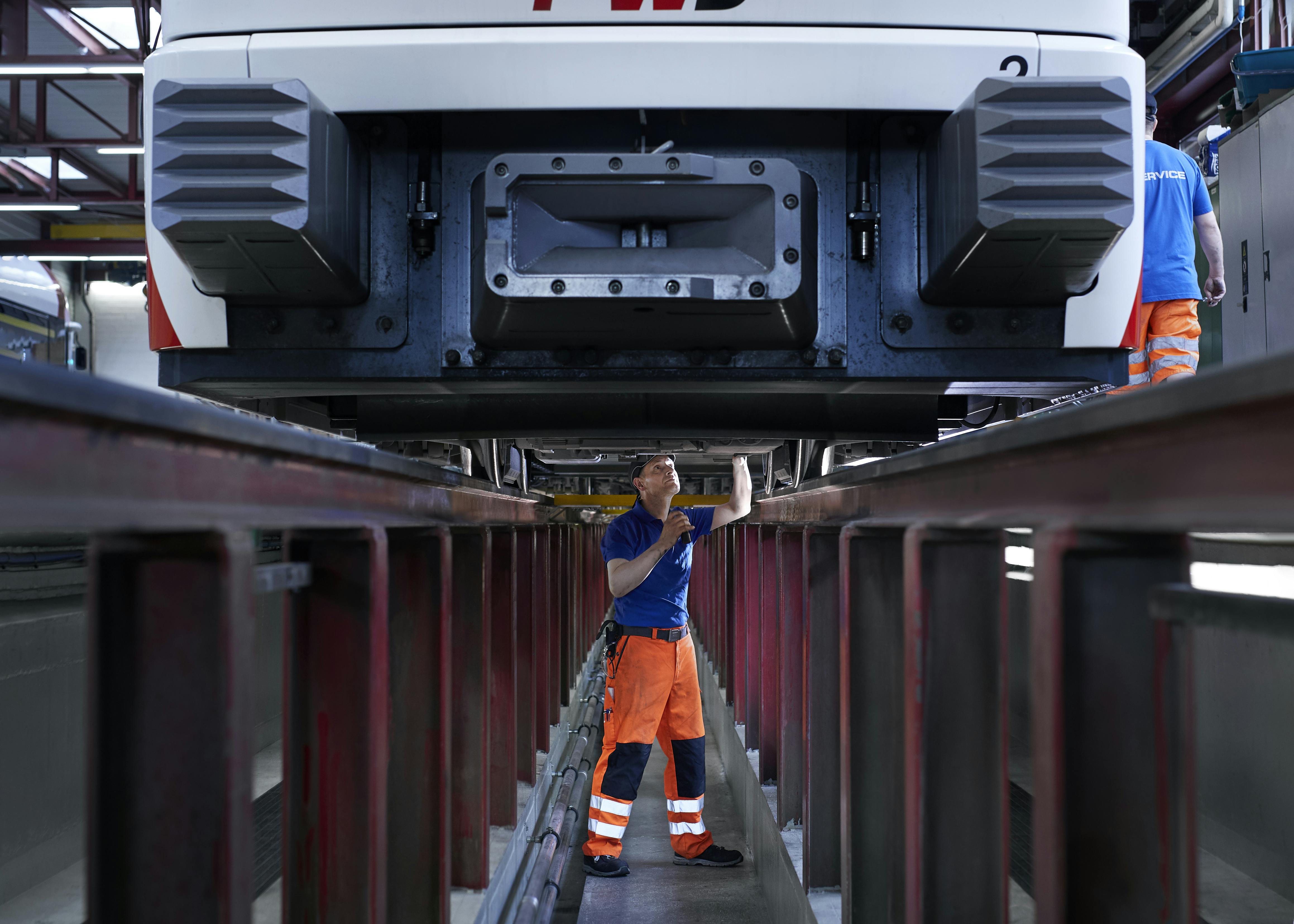 Male worker fixing a train.