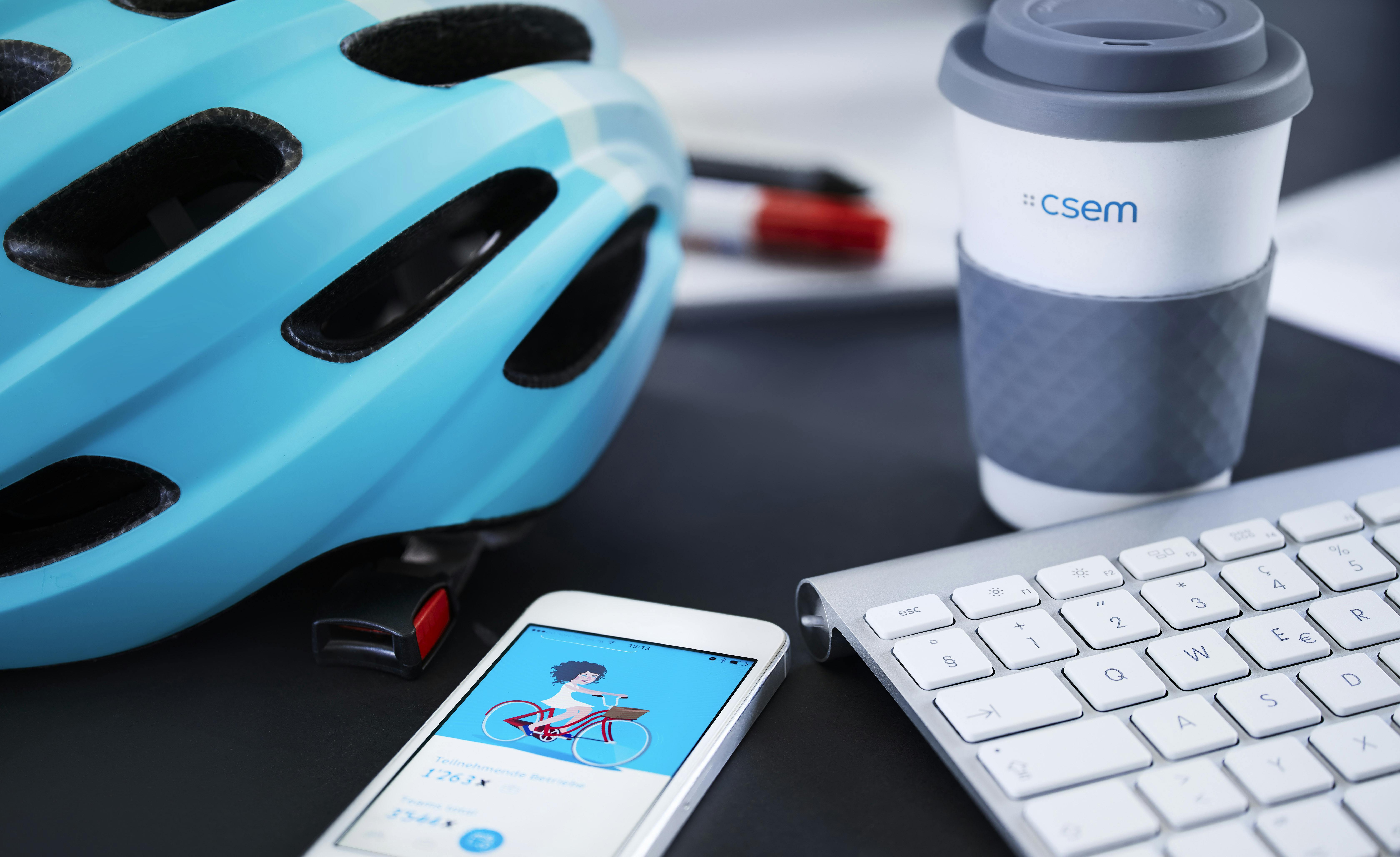 Smartphone, keyboard, cup and helmet on a CSEM desk 