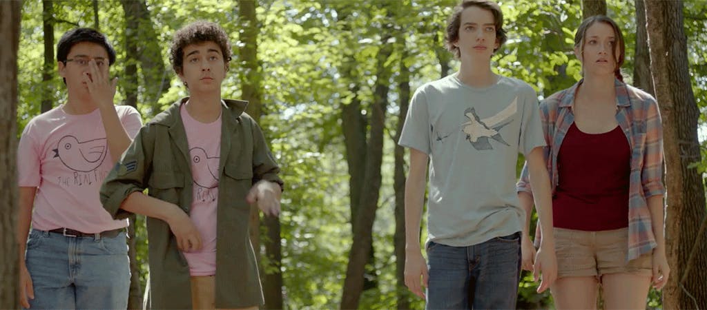 Four teenagers standing in the woods
