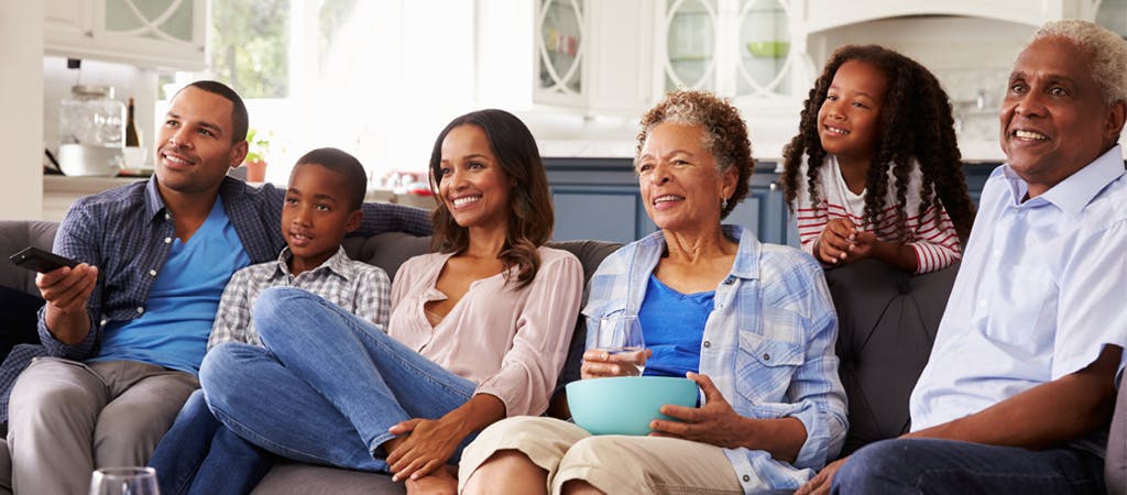 Family of six on couch watching screen