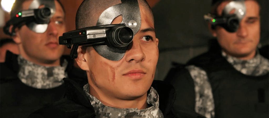 three uniformed men wearing electronic devices covering their right eyes