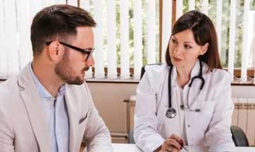 Woman Doctor speaking to hospital administrator at desk