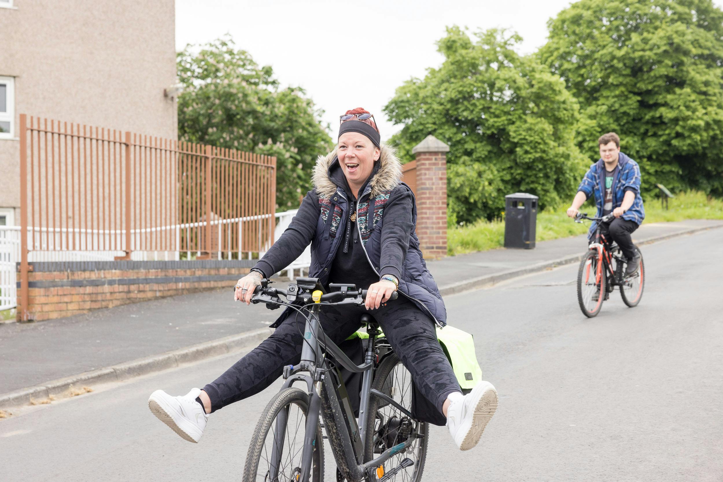 Lady cycling with her legs stretched out in a joyous way