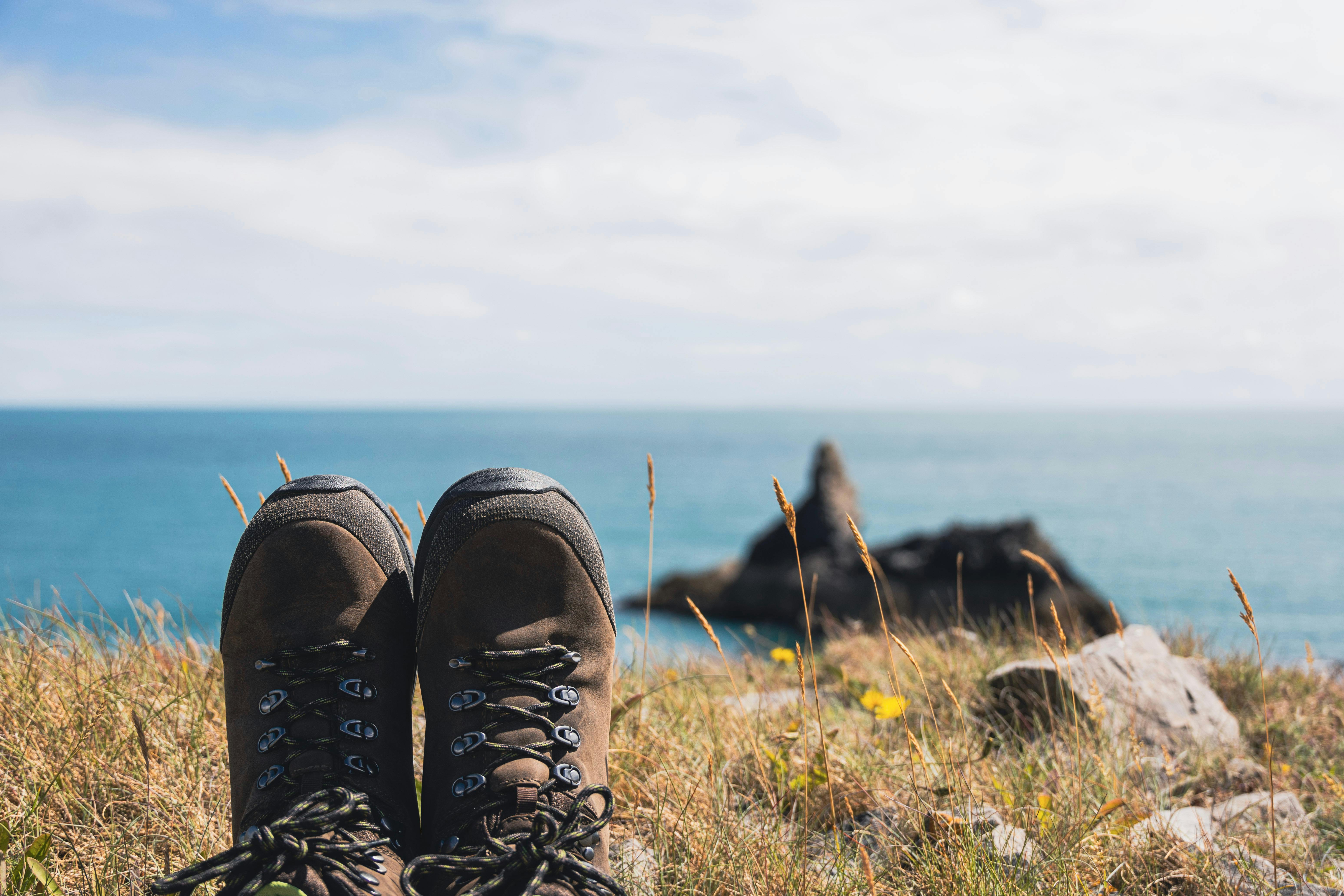 A pair of walking boots overlooking a beach