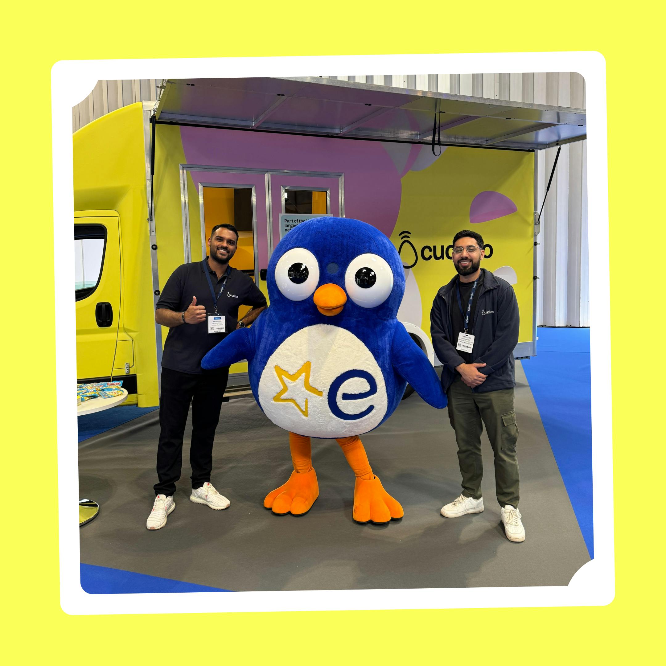 Cuckoo team members next to Euronics Penguin mascot. 
