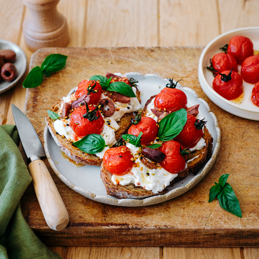 Bruschetta con tomates cherry, stracciatella y aceitunas