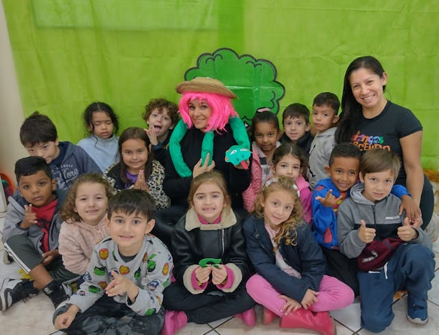 Crianças junto com as professoras em uma peça teatral