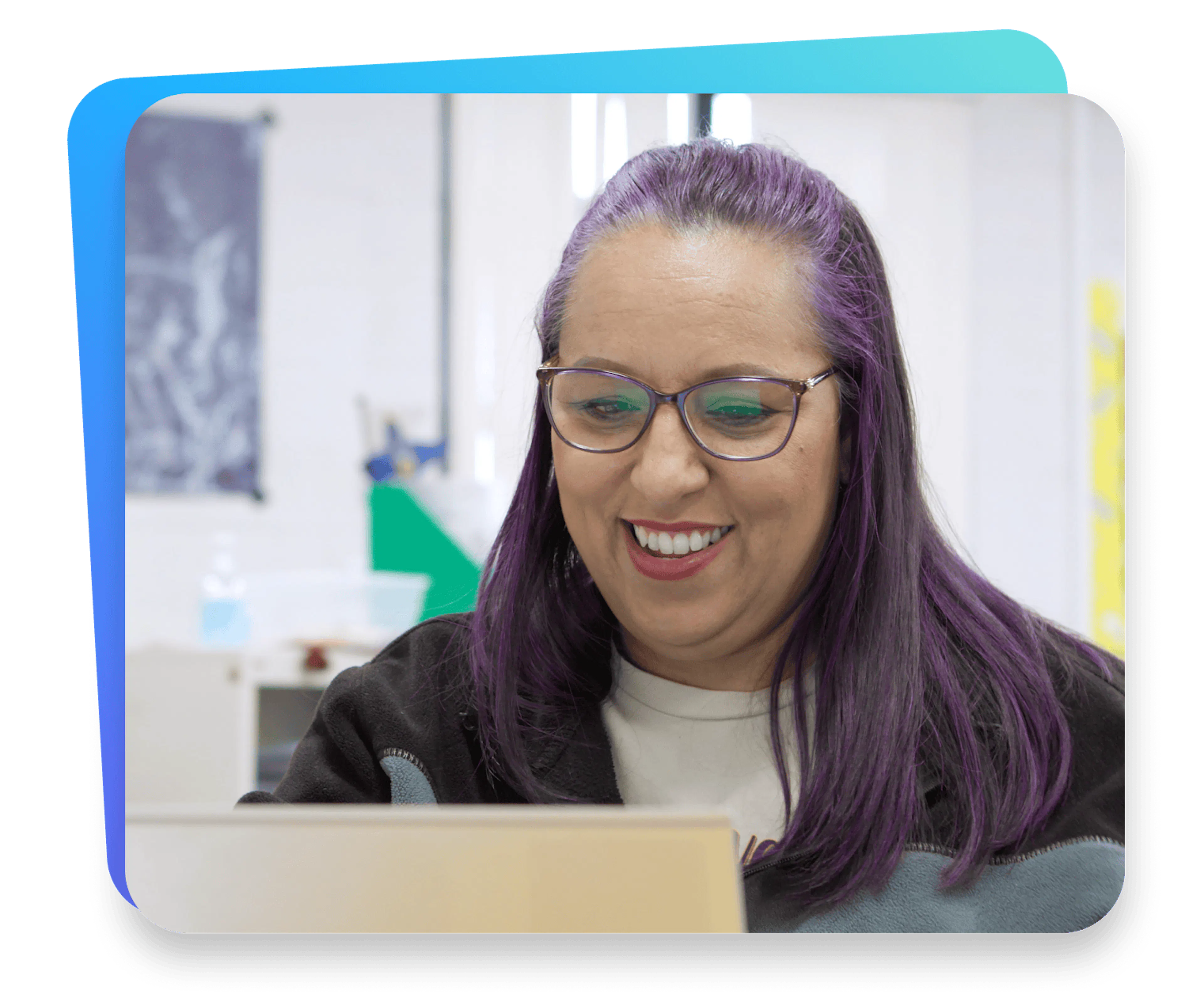 Image of a teacher smiling and using a laptop