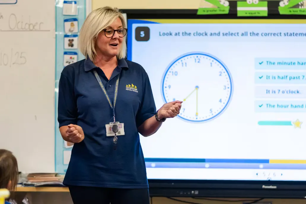 Teacher teaching a lesson in front of an interactive whiteboard