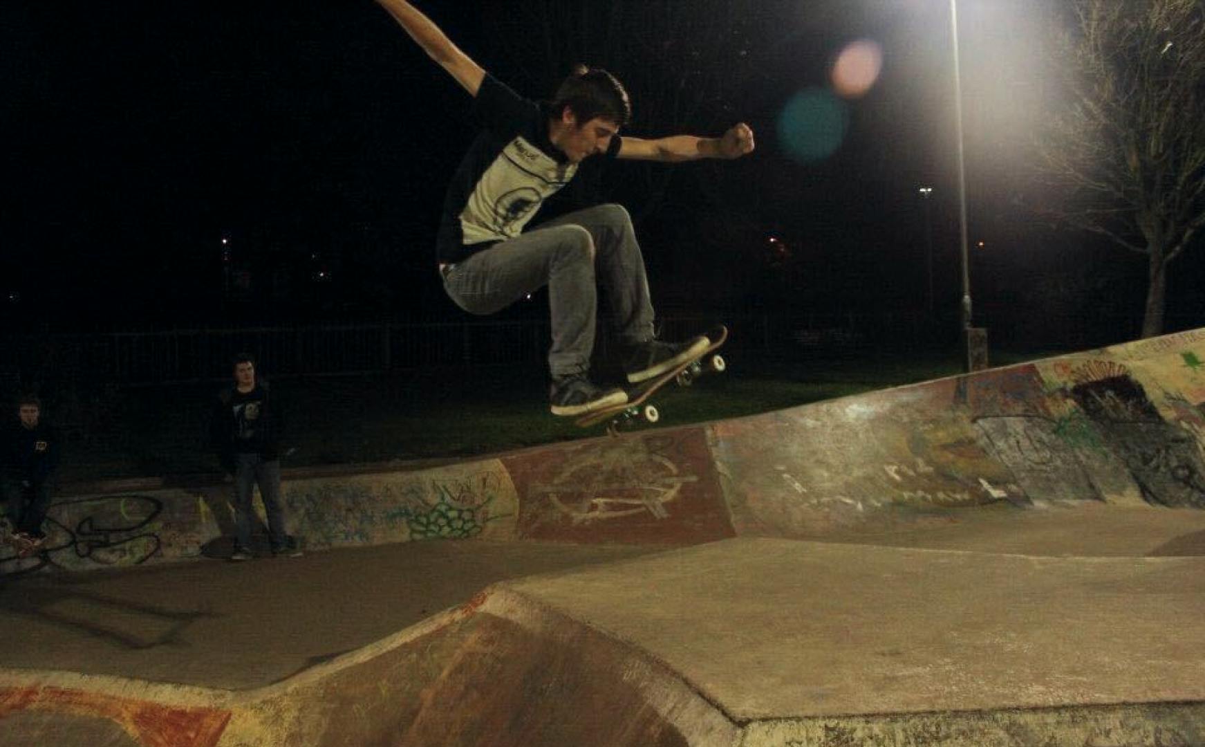 David doing a skateboarding trick at a skate park