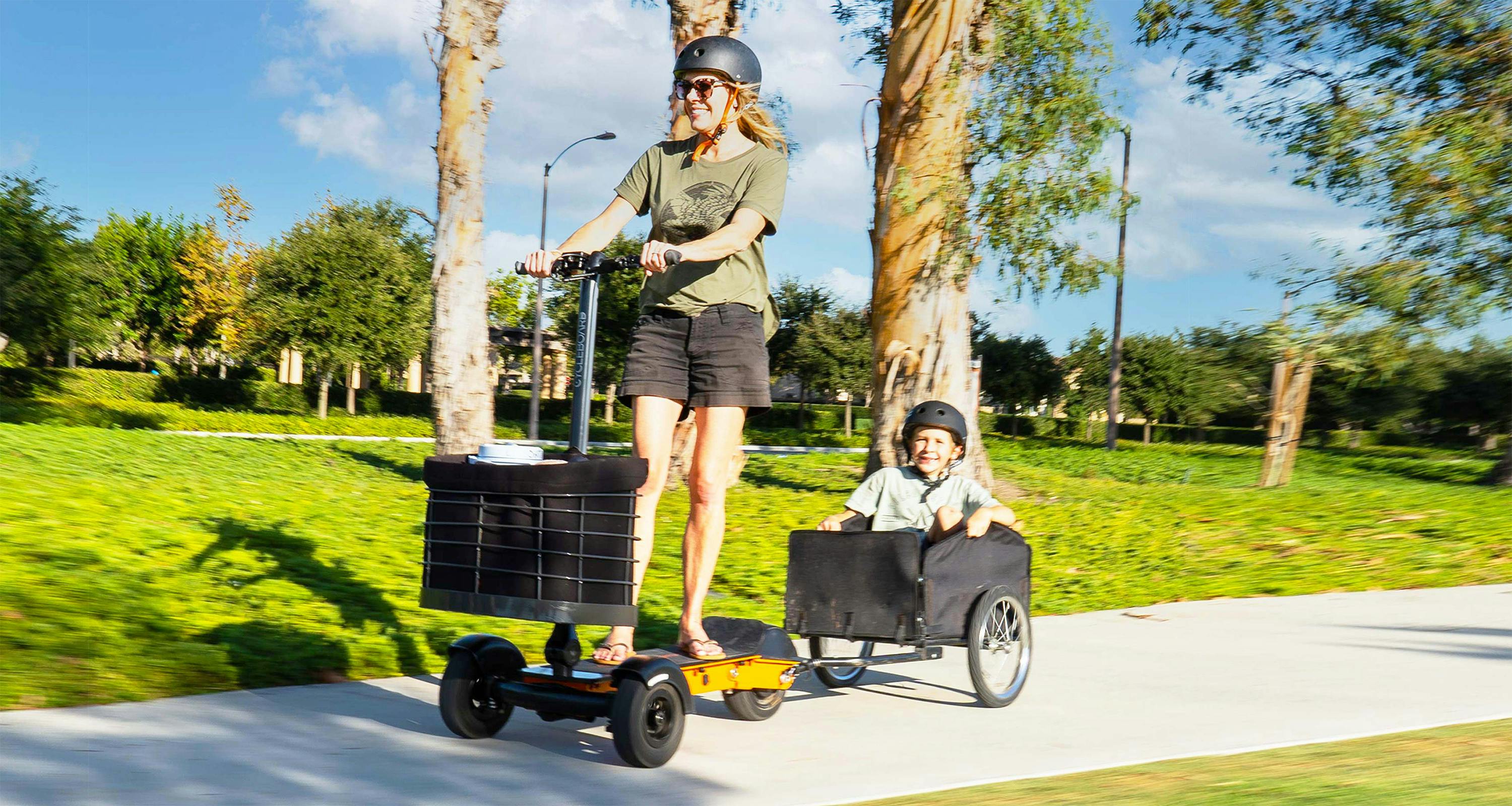 mother and son riding to park together in safe 3 wheel electric scooter