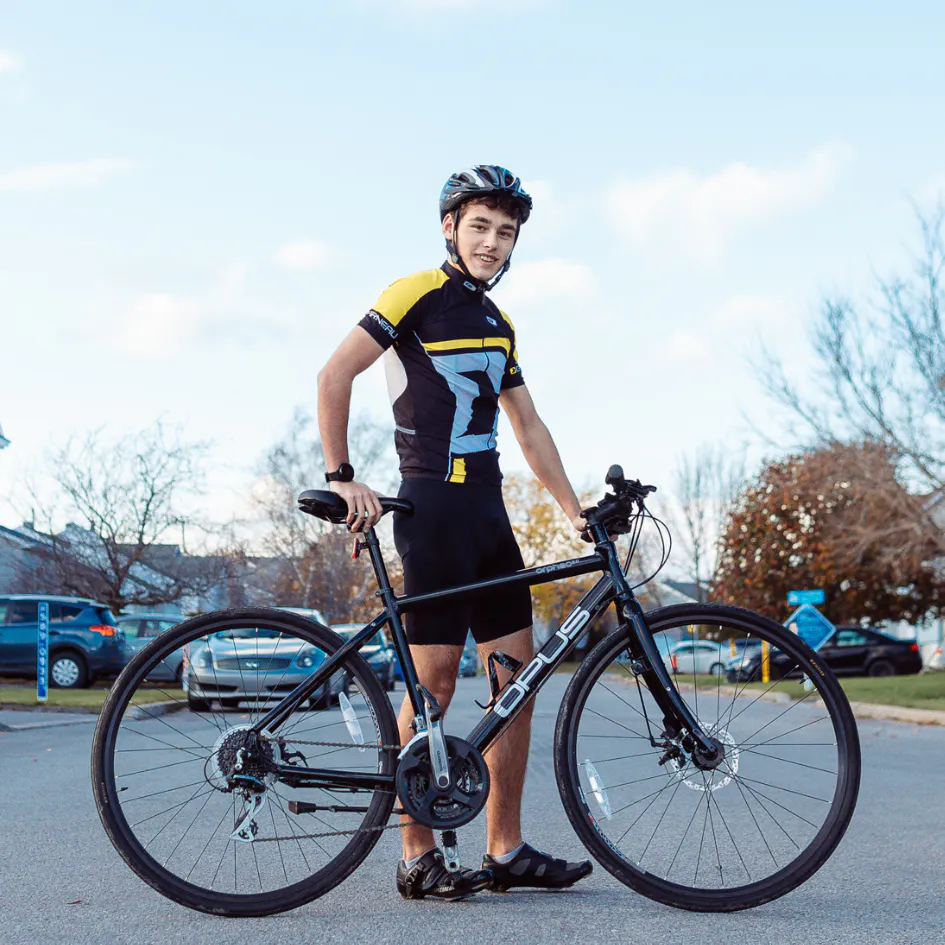 Une cycliste atteinte de la fibrose kystique pose avec son vélo.