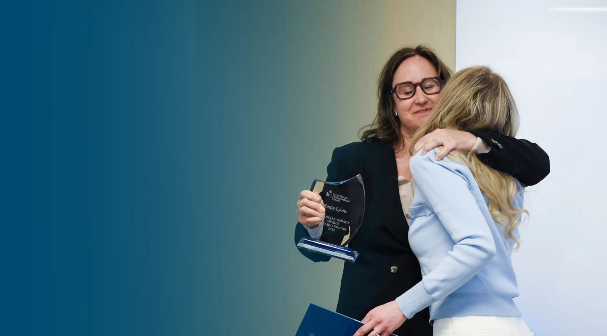CEO, Kelly Grover, hugs a community award recipient.