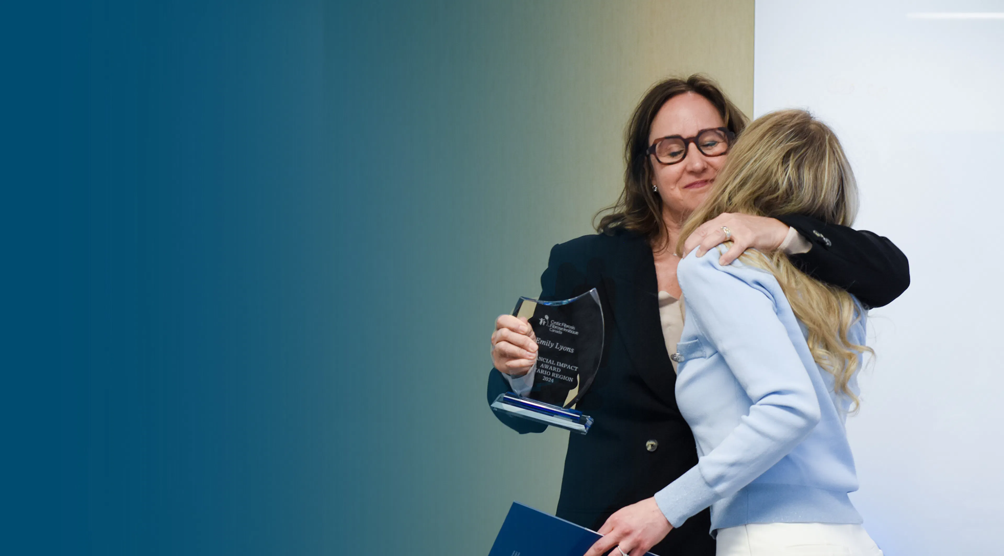 CEO, Kelly Grover, hugs a community award recipient. 
