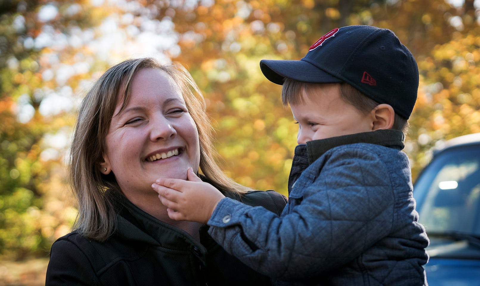 mother smiles as toddler caresses her chin