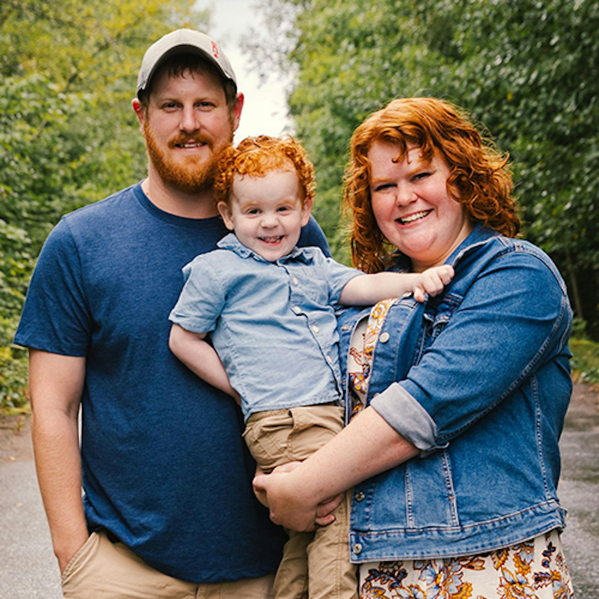 Bethany, her husband Jonathan, and their young son, Zachary, pose in a forest for a family photo. 