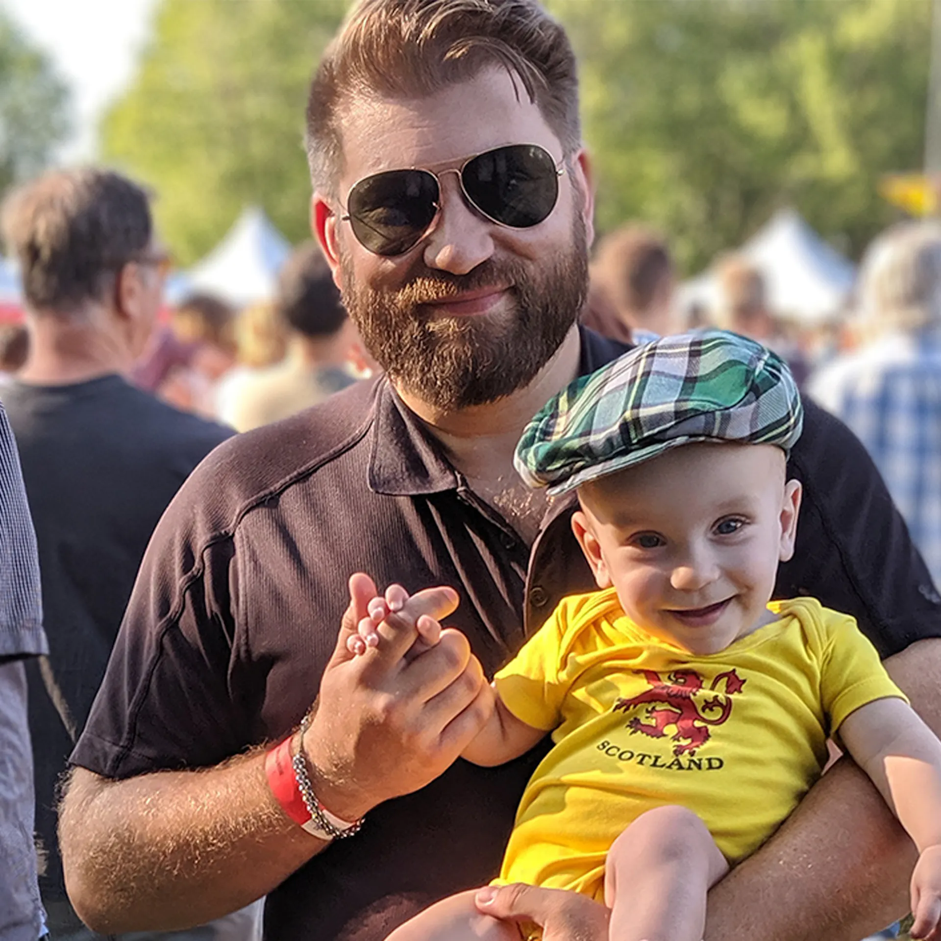 James Fournier holds his wee babe wearing a tartan cap.