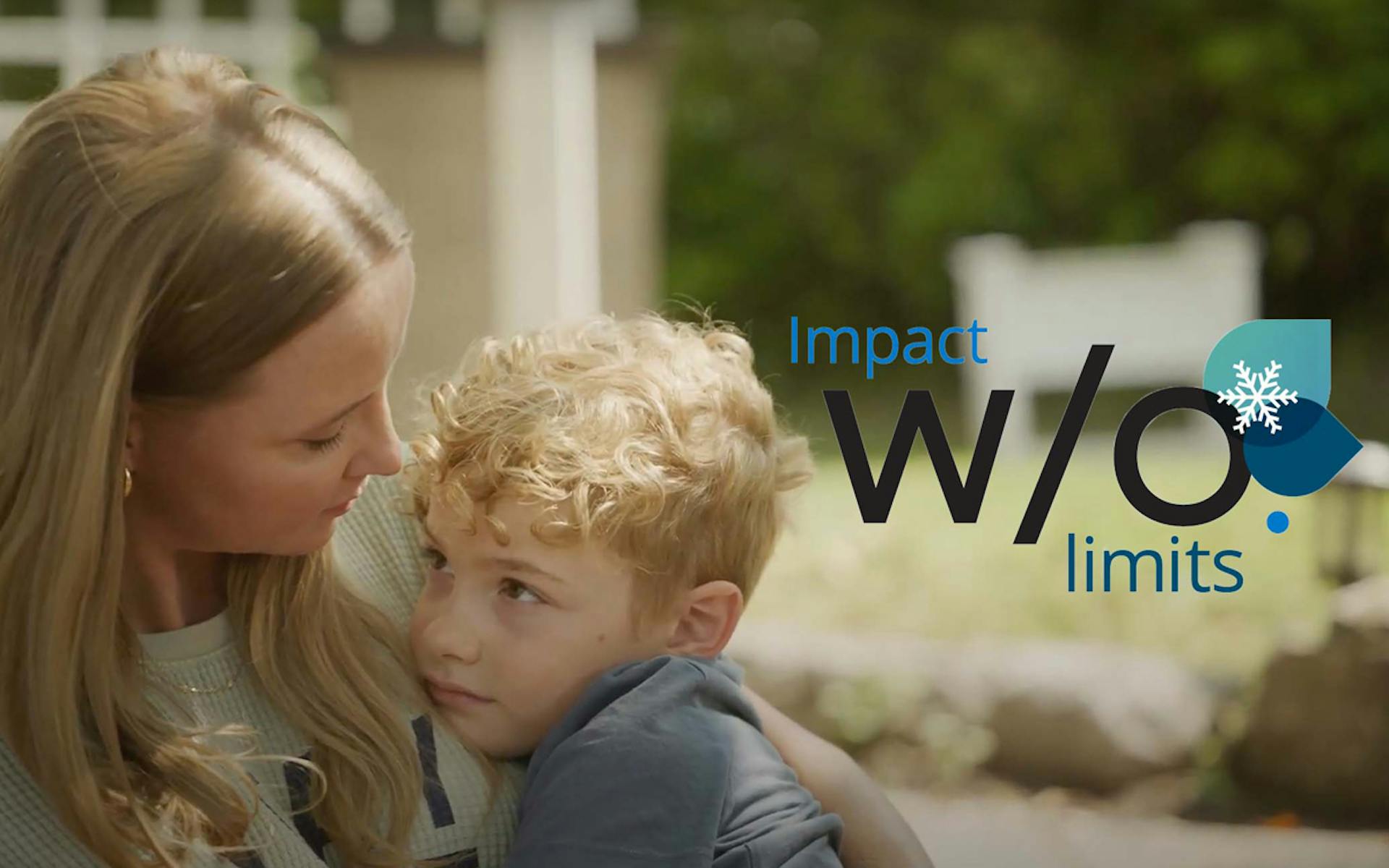 Mother holds young boy sitting on a porch step