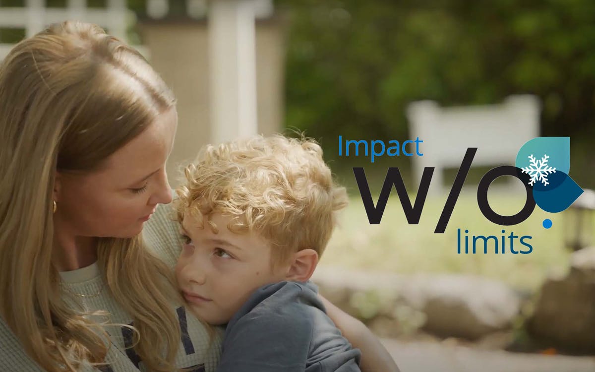 Mother holds young boy sitting on a porch step