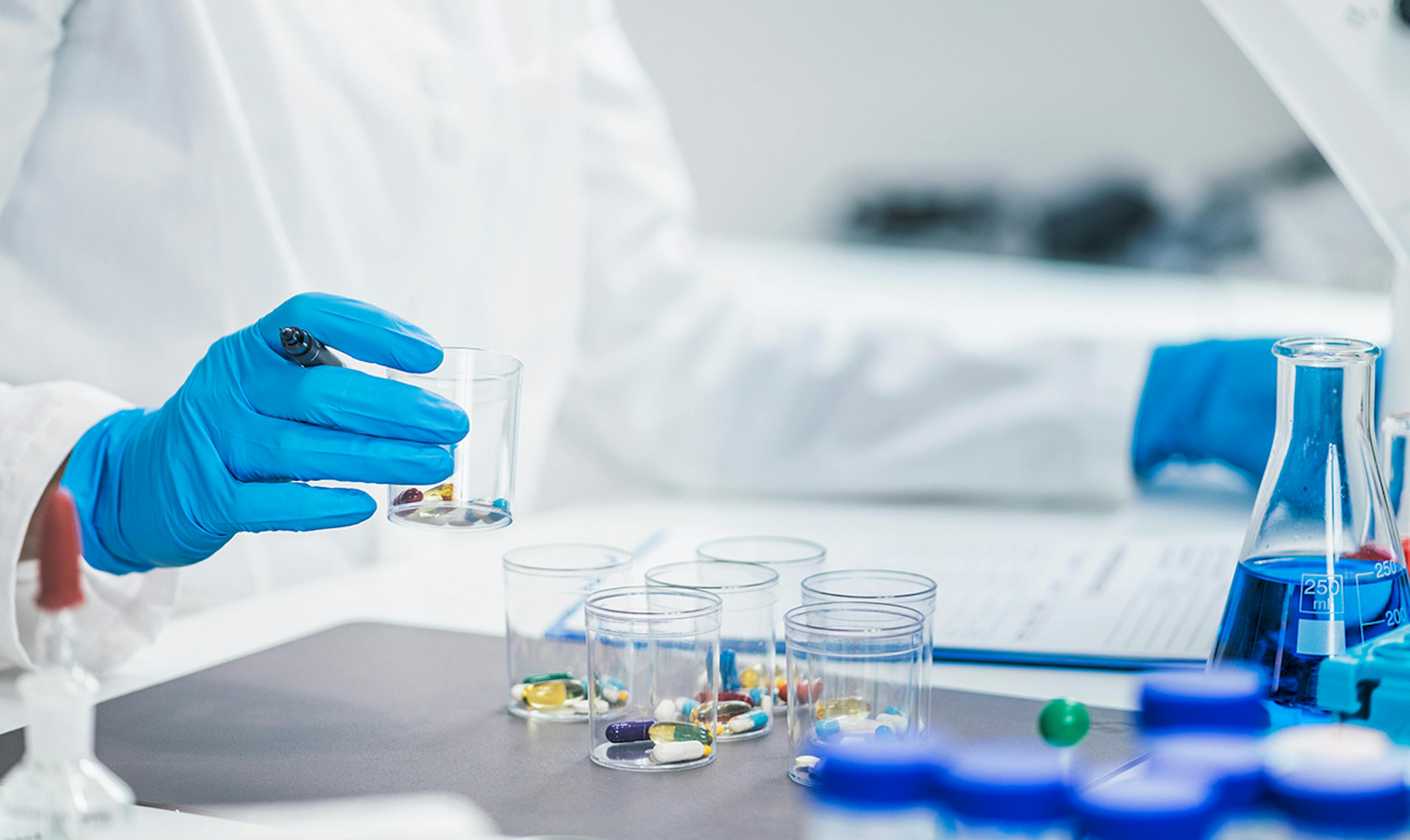 Researcher handling containers of medicines to be tested