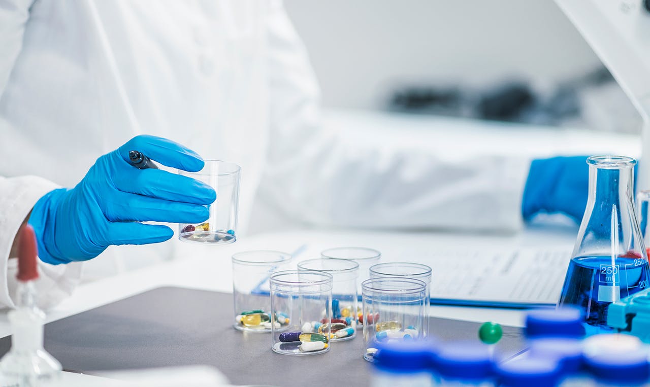 Researcher handling containers of medicines to be tested