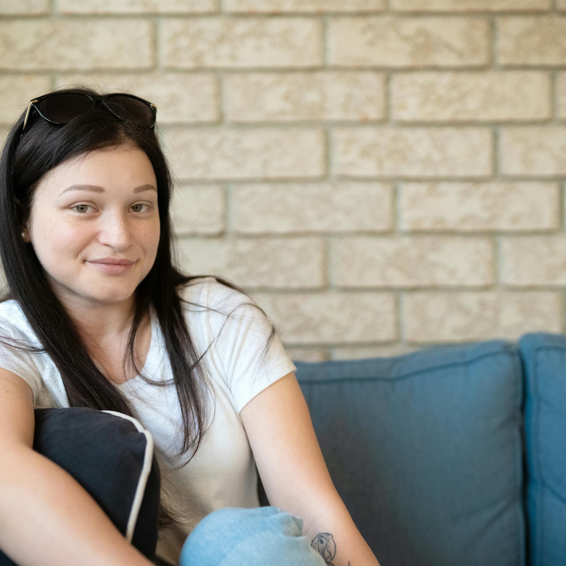 young woman relaxing on couch looks at camera