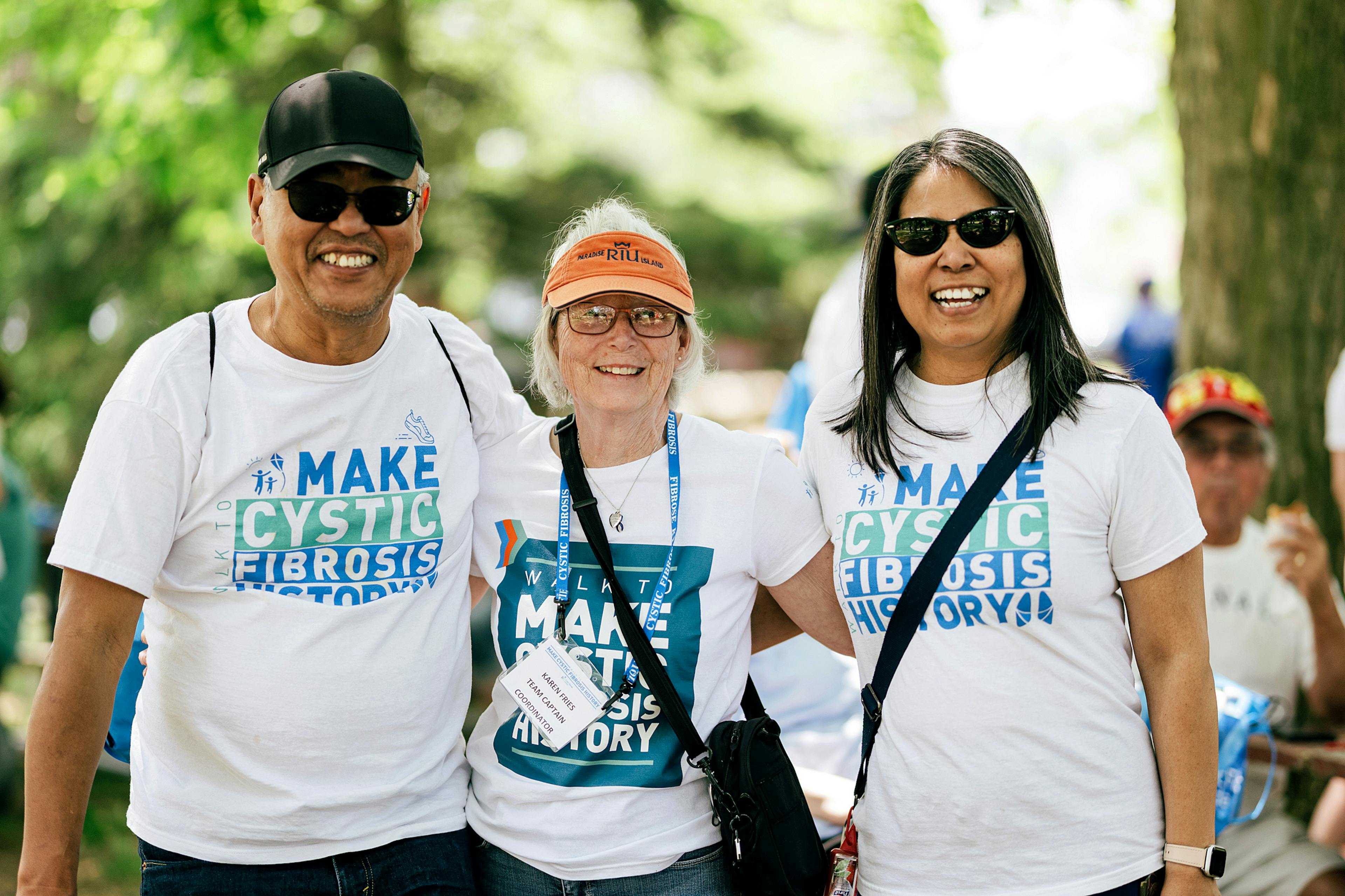 one man and two women walk together in Walk event t-shirts