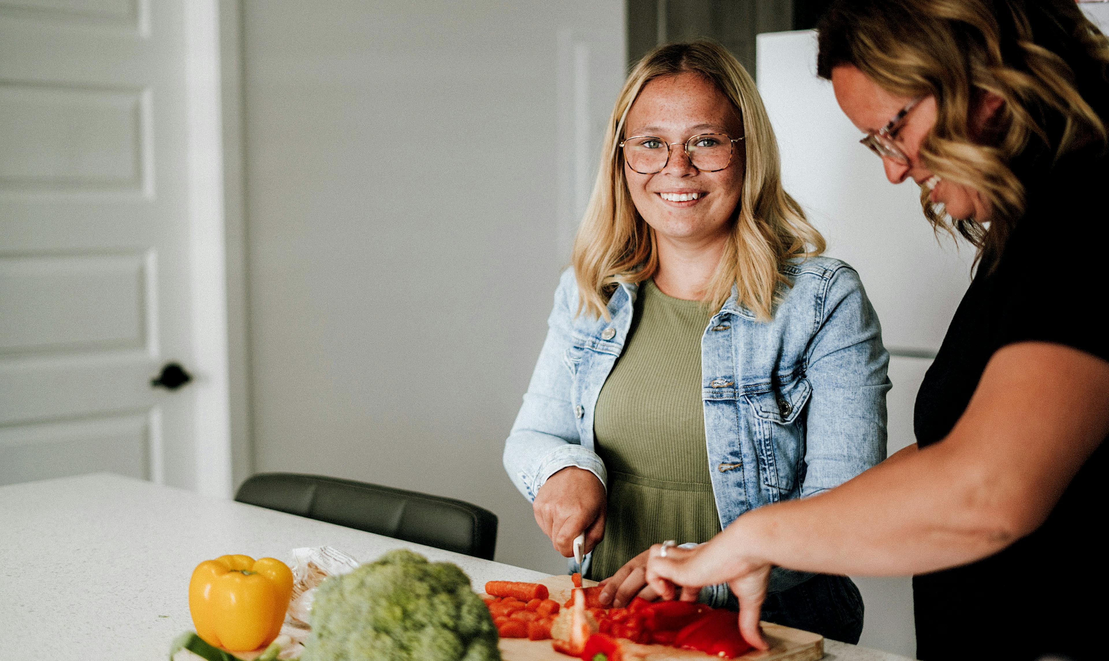 young woman prepares a meal with her mother