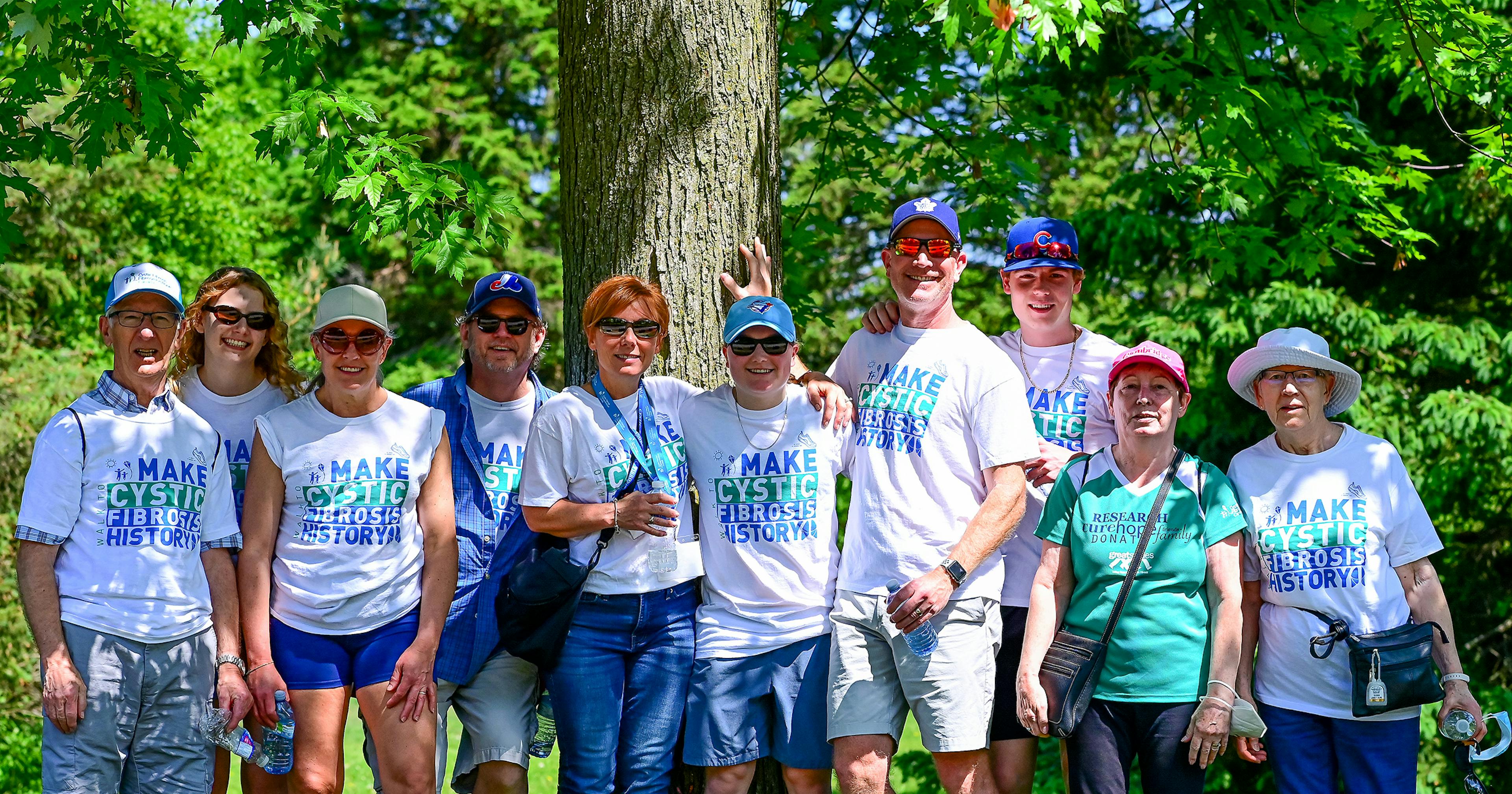 Group of walk participants standing by a tree.