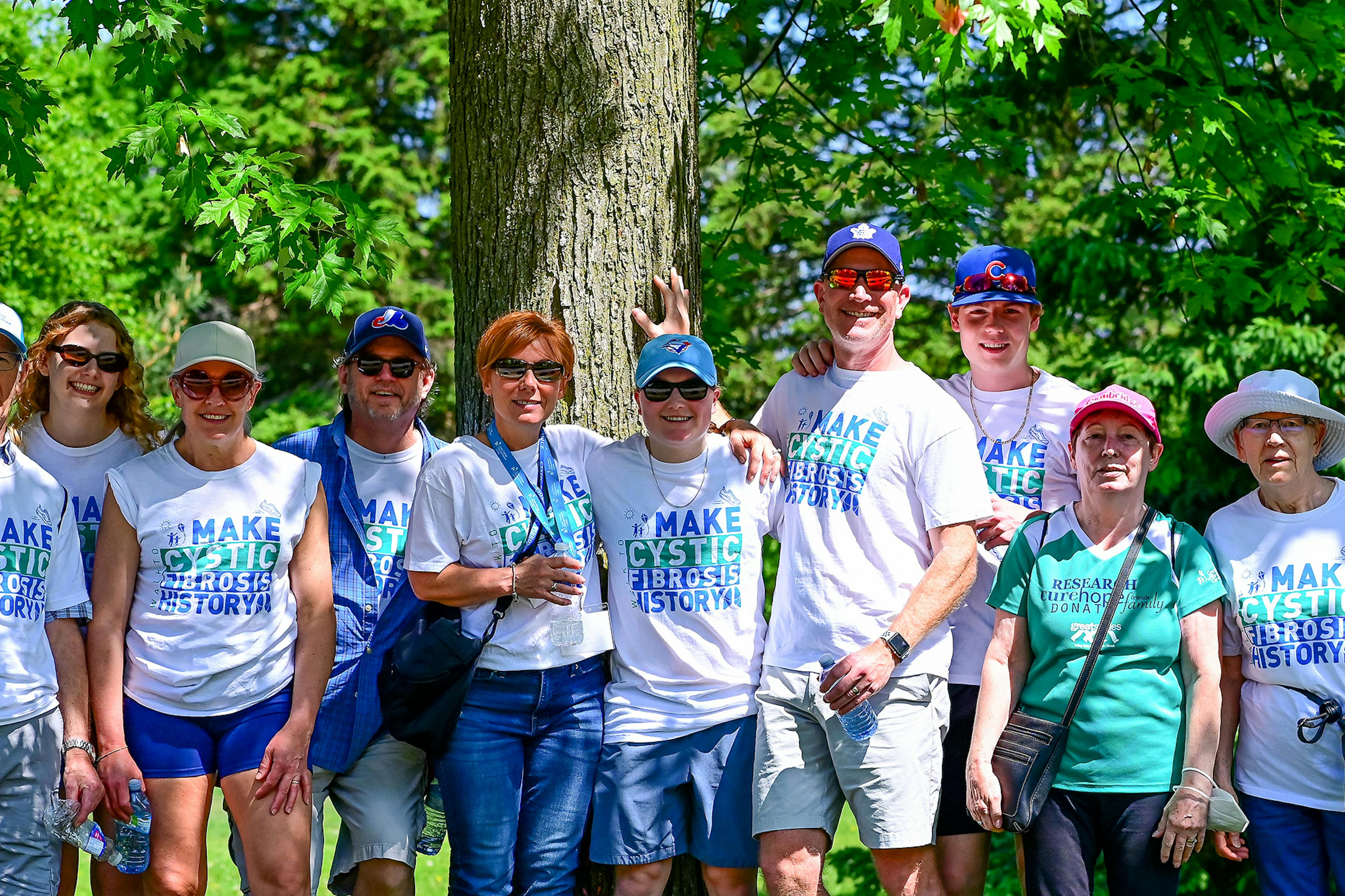 Group of walk participants standing by a tree.