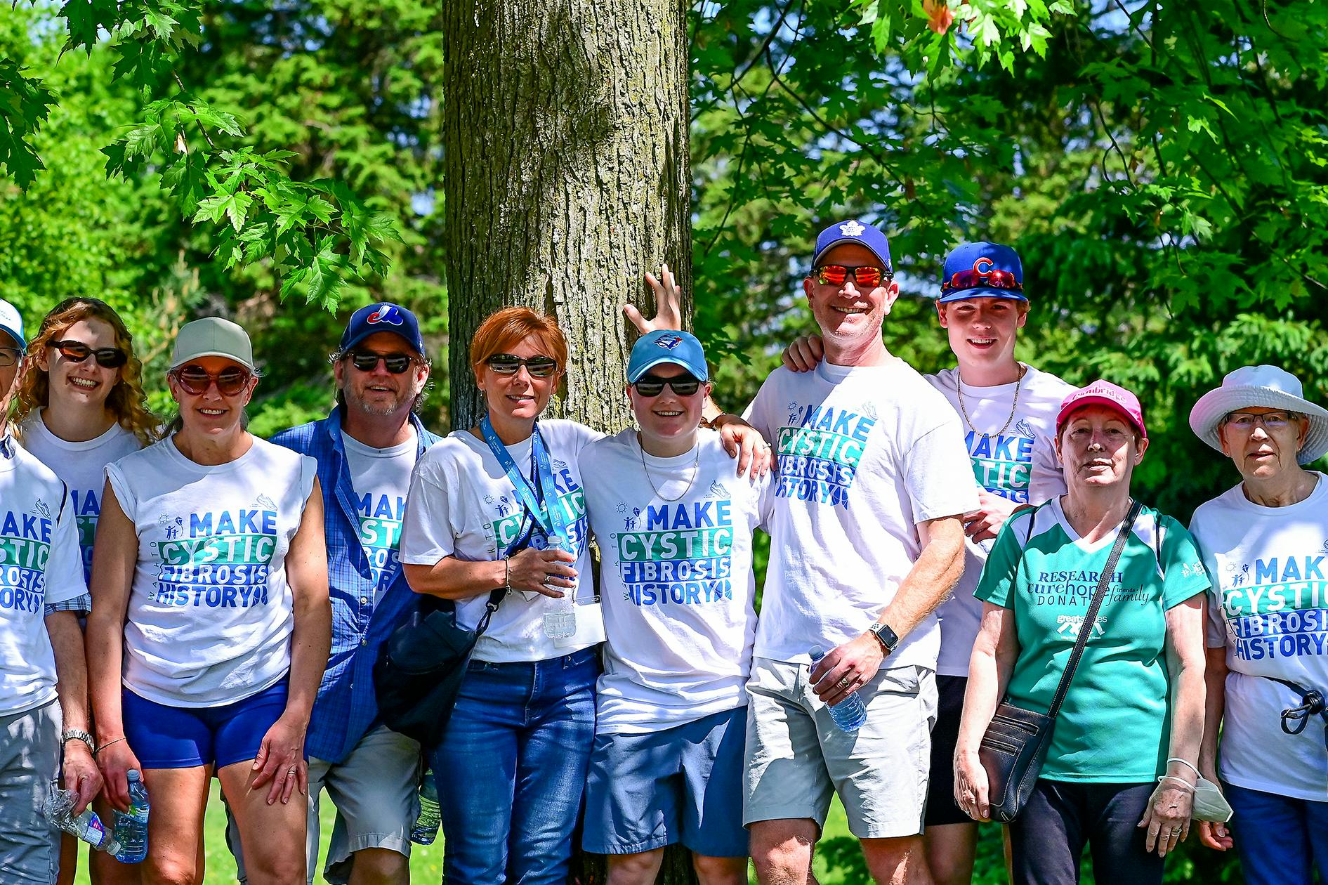 Group of walk participants standing by a tree.