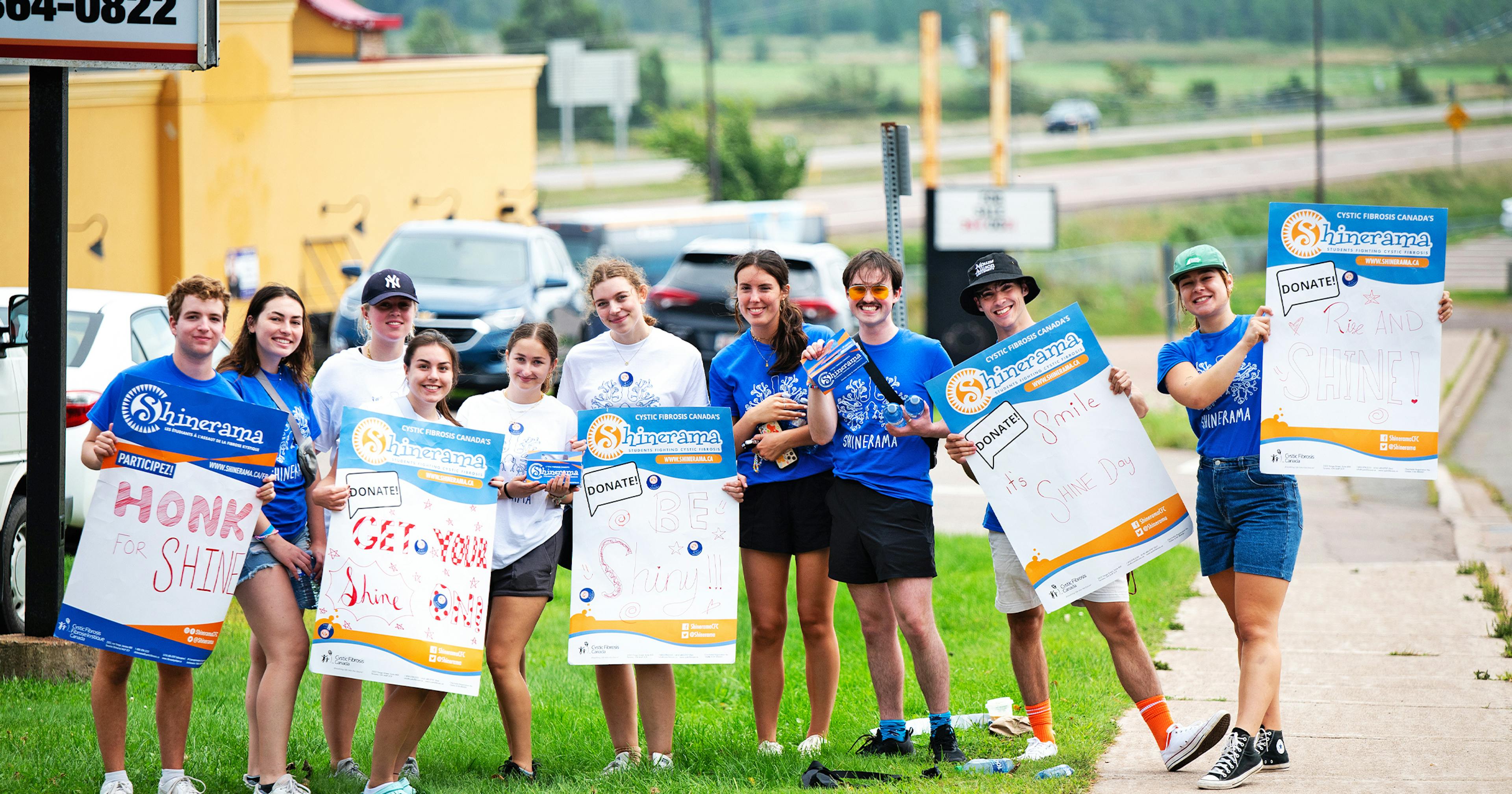 group of students holding car wash signs