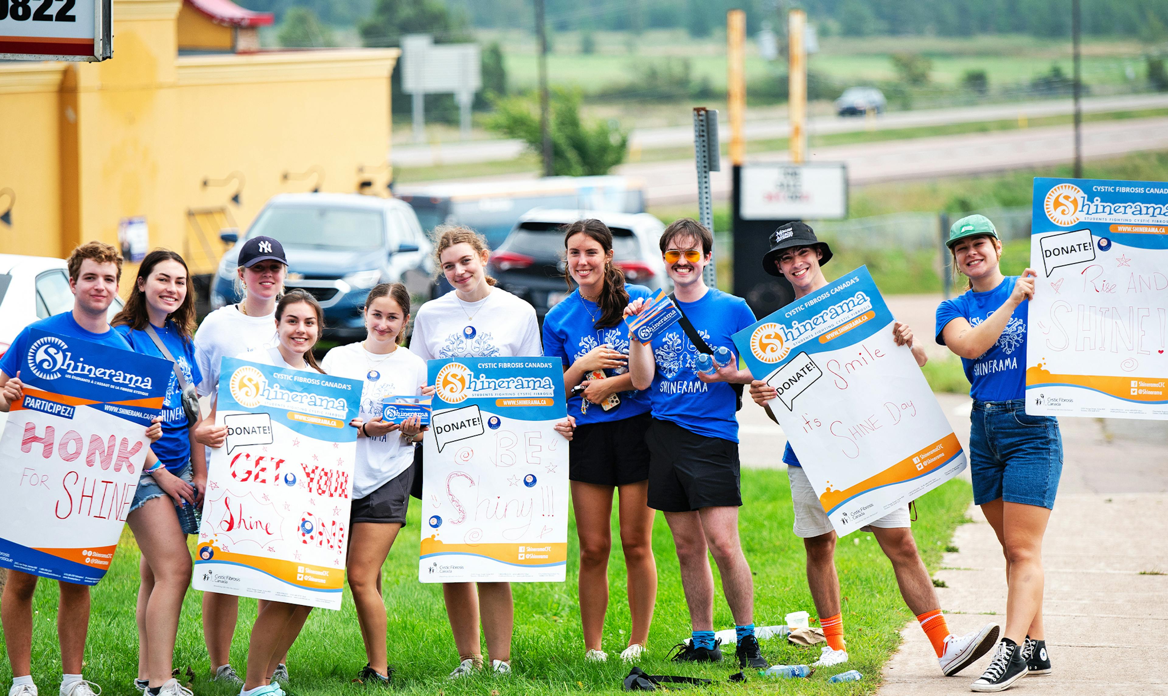 group of students holding car wash signs