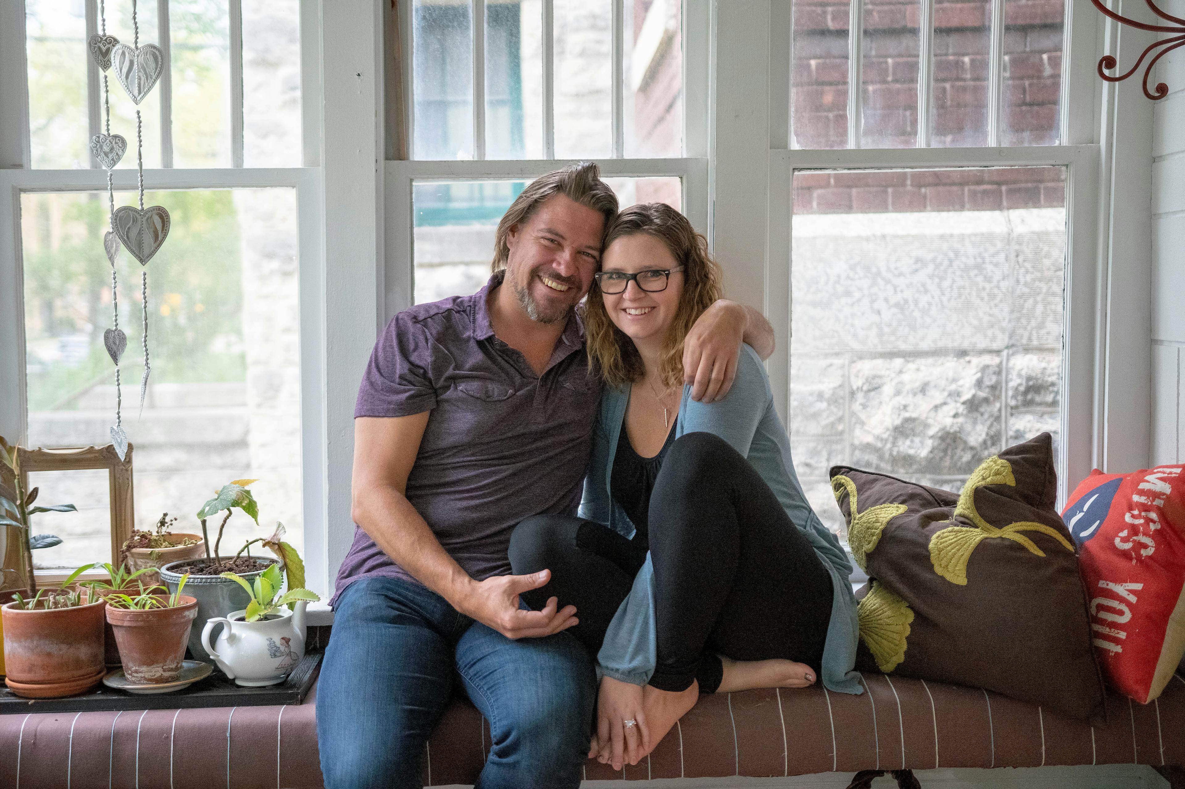 man and woman embrace and smile to the camera