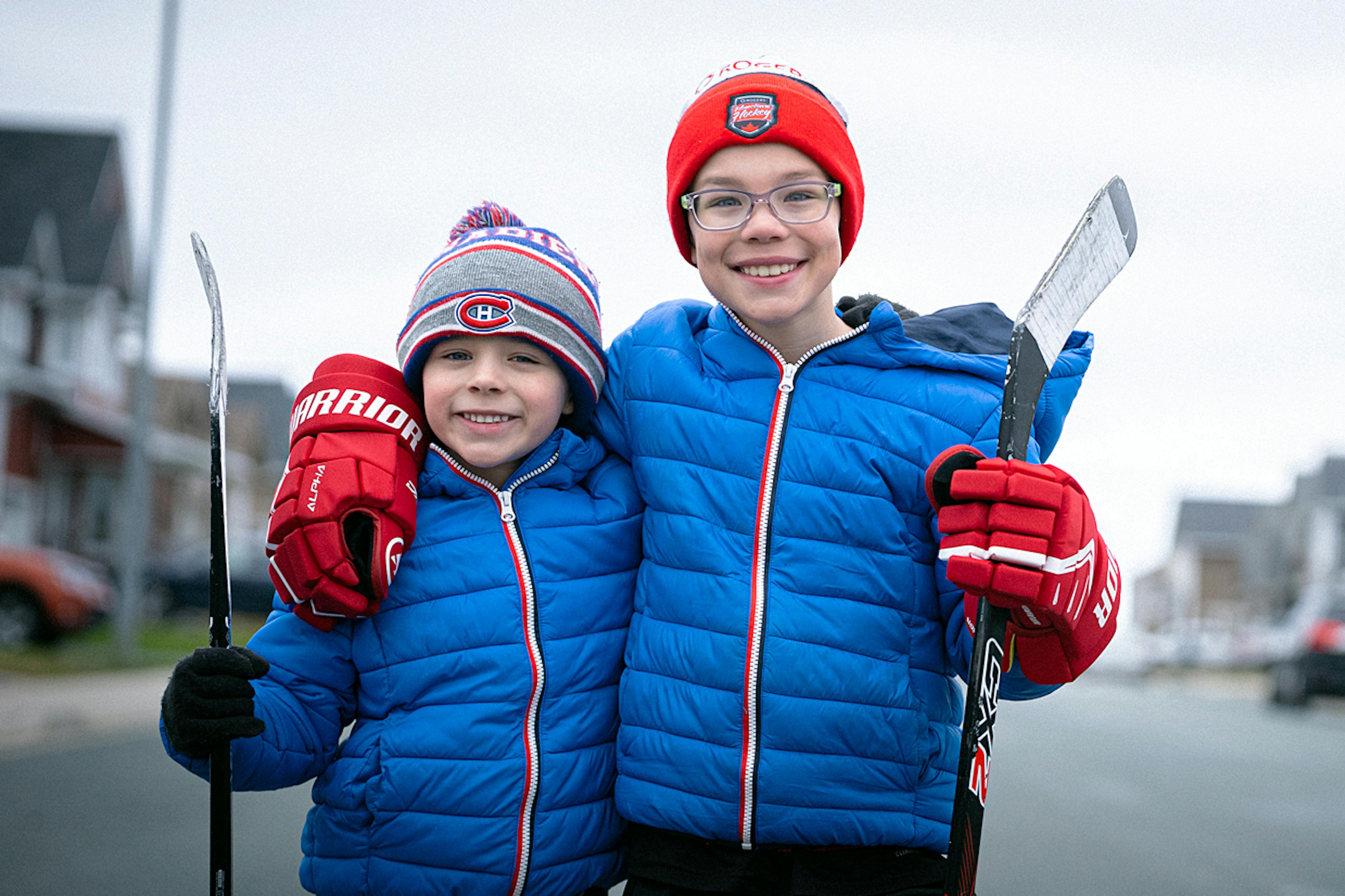 deux jeunes garçons en équipement de hockey s'étreignent en souriant