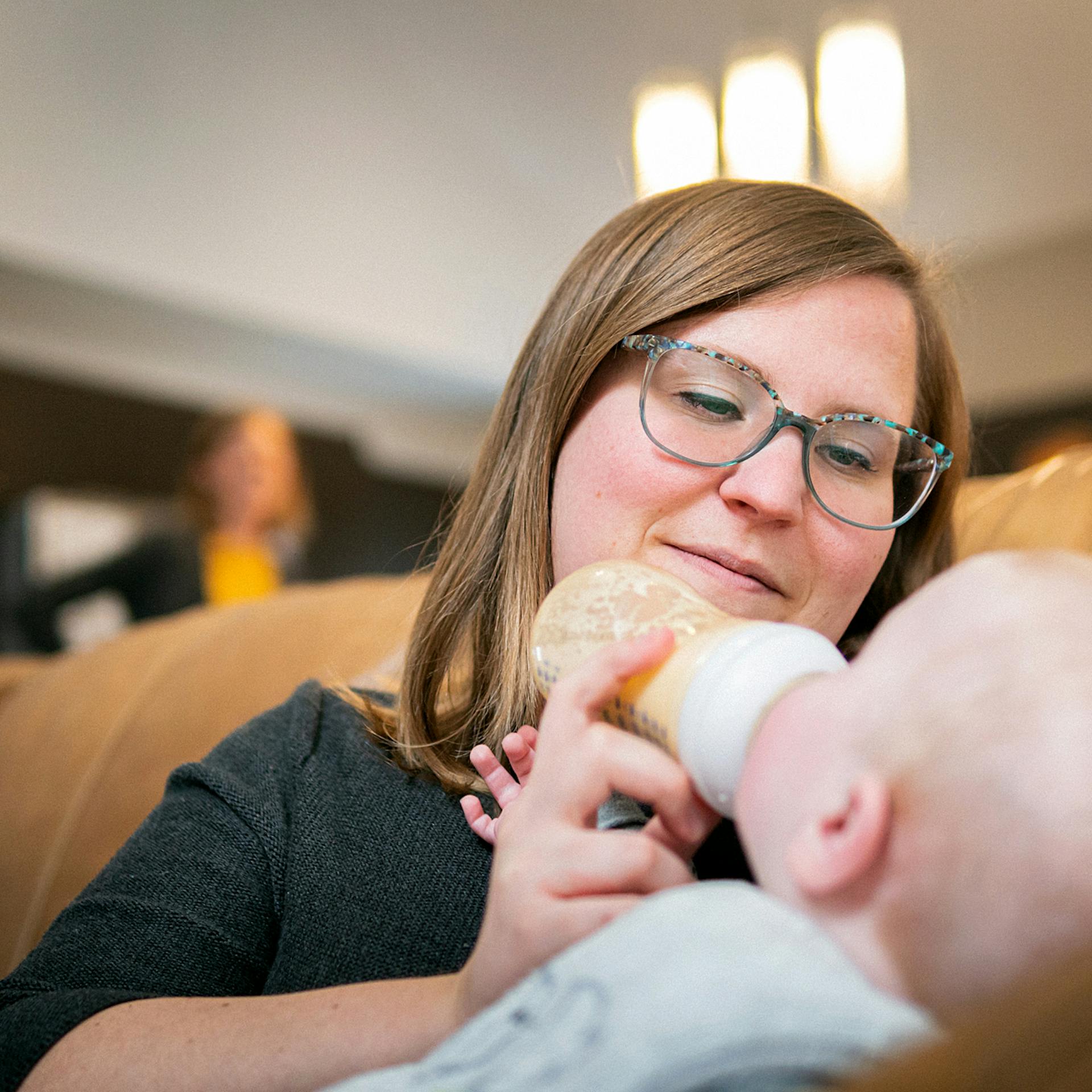 a mother feeds her baby a bottle