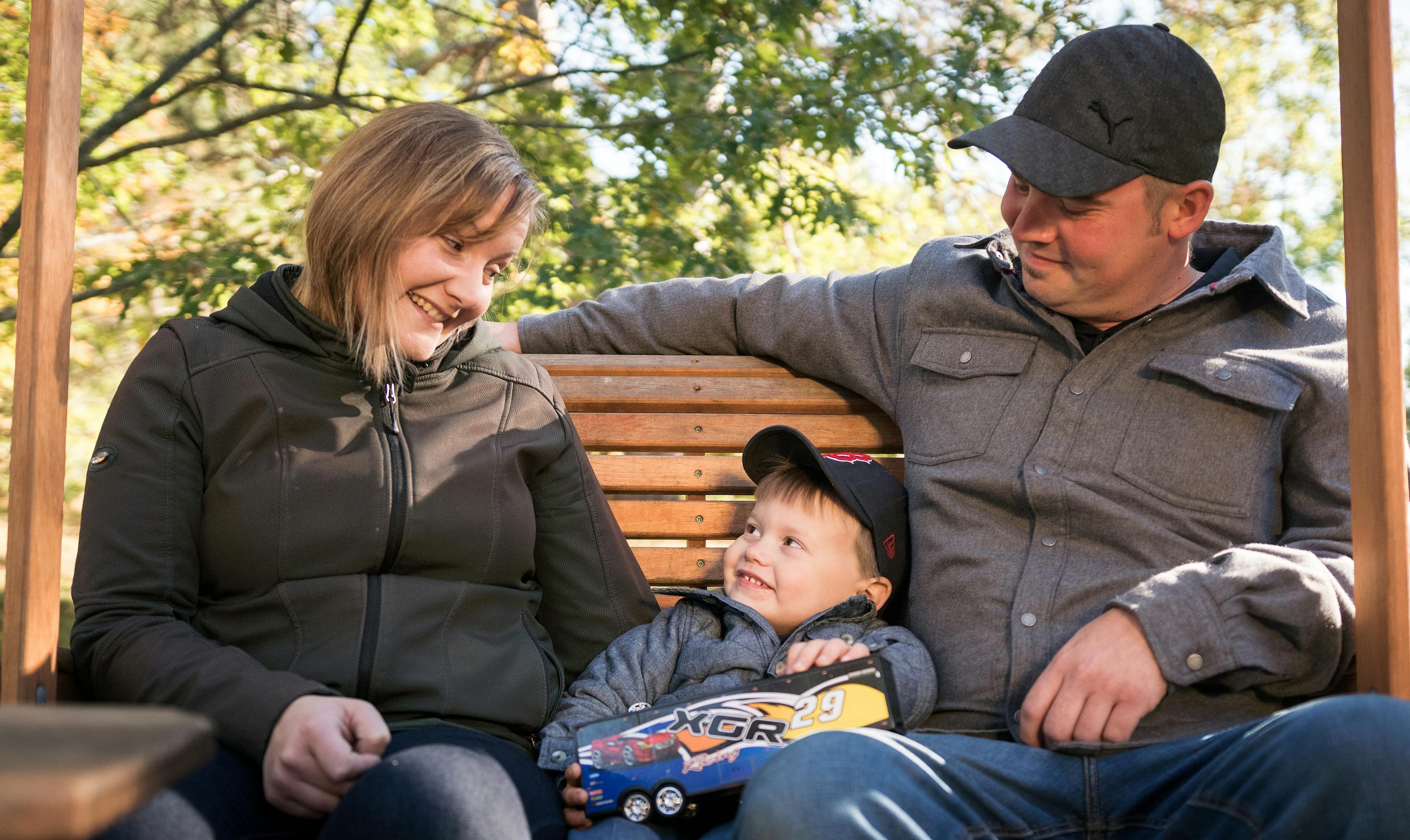 deux parents regardant leur jeune fils dehors