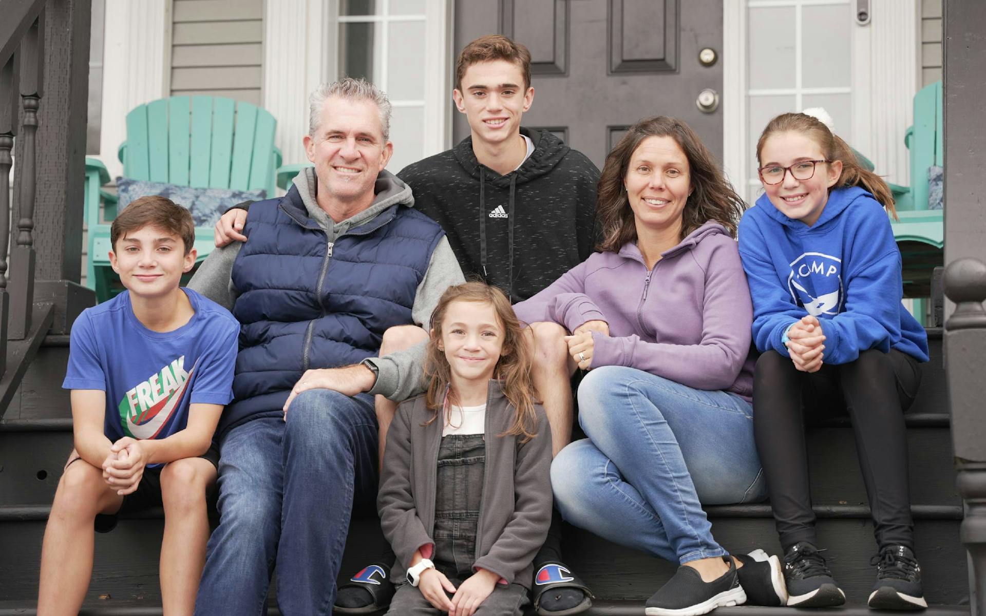 Rachel Miller and her family sitting on the stairs of their front porch.