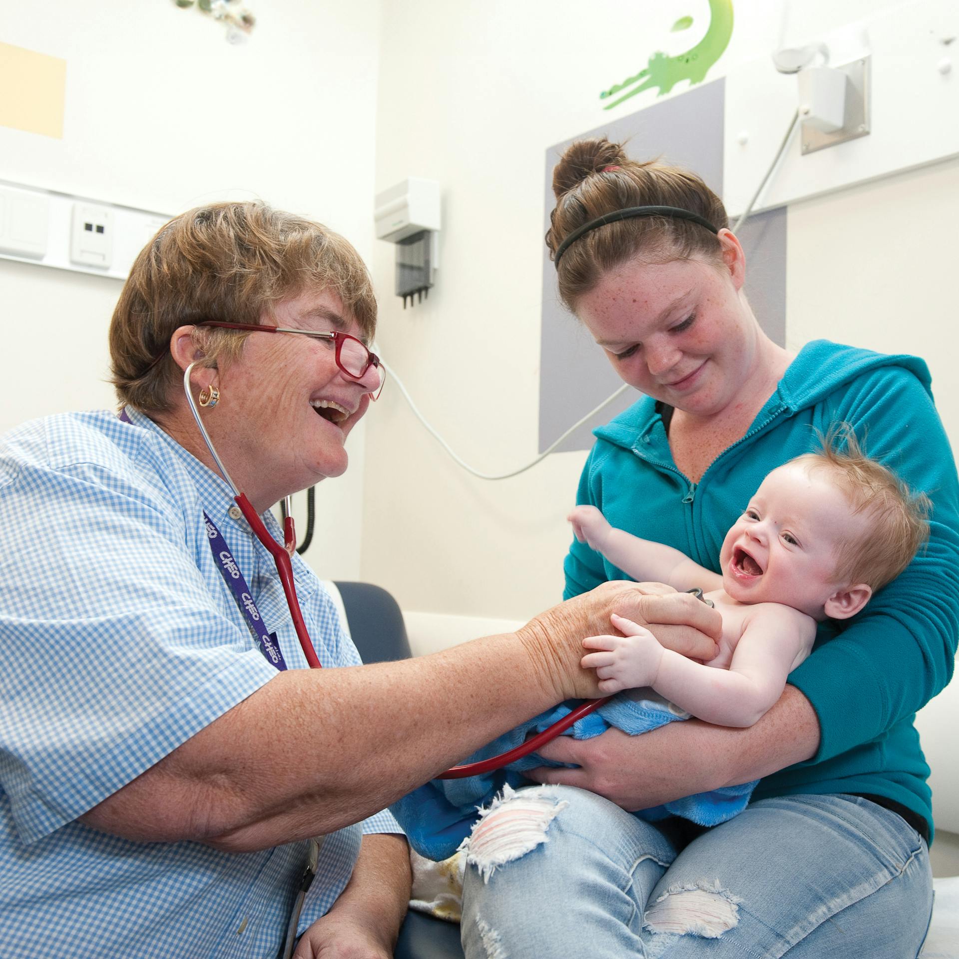 Woman doctor attends to baby being held by her mother