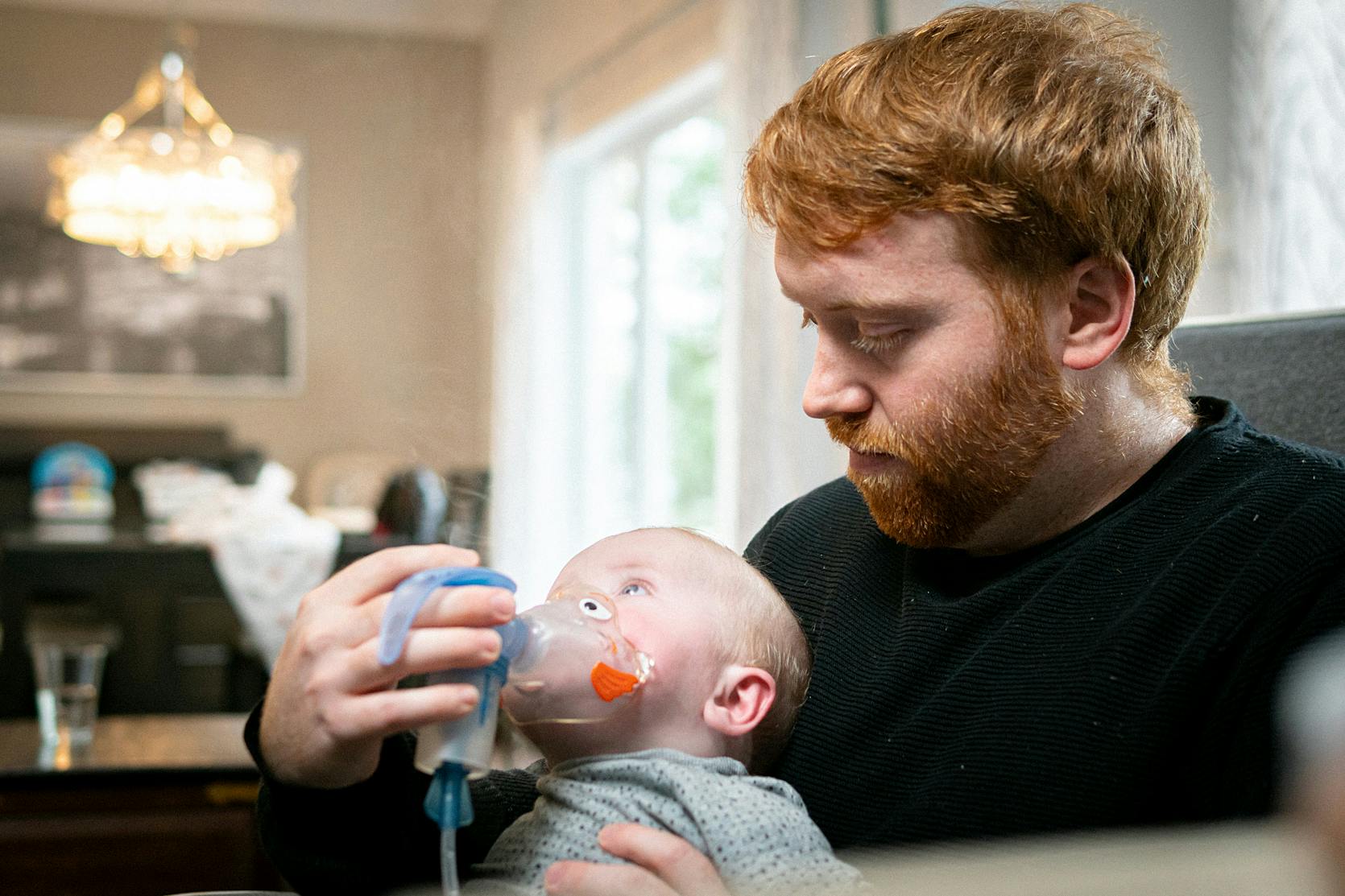 a man helps a baby breathe using an apparatus