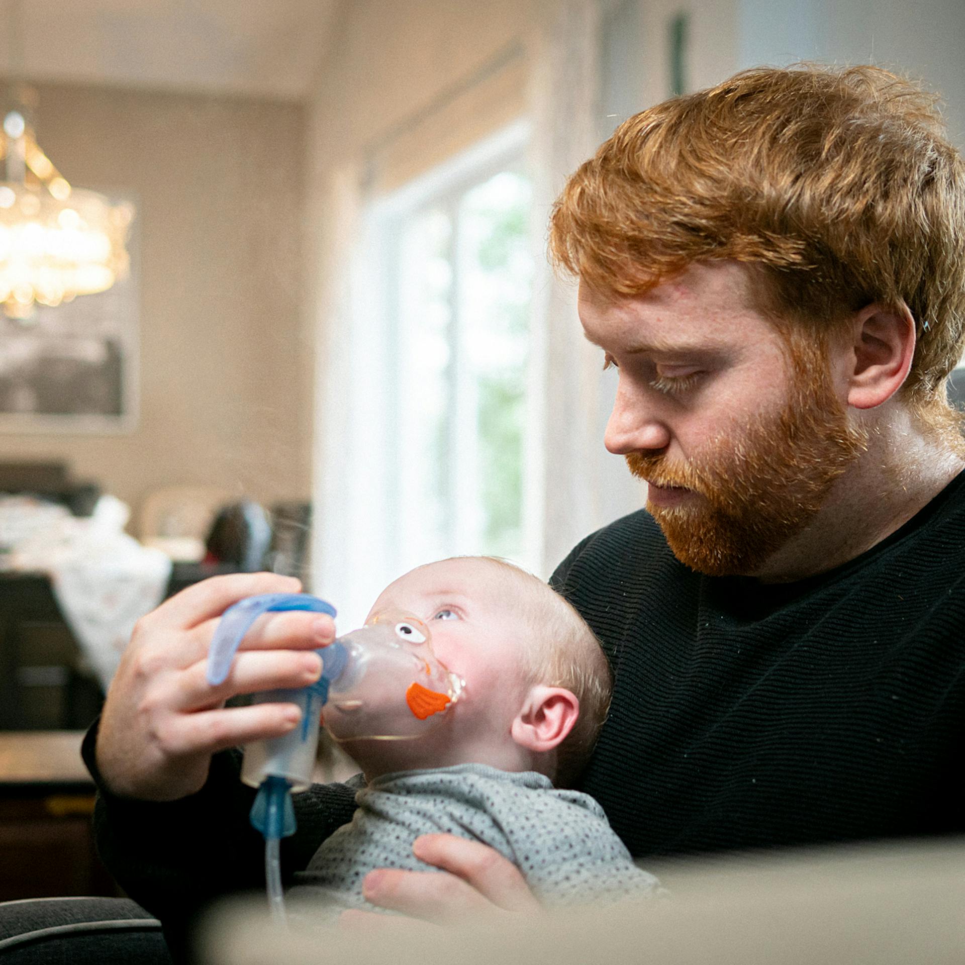 a man helps a baby breathe using an apparatus